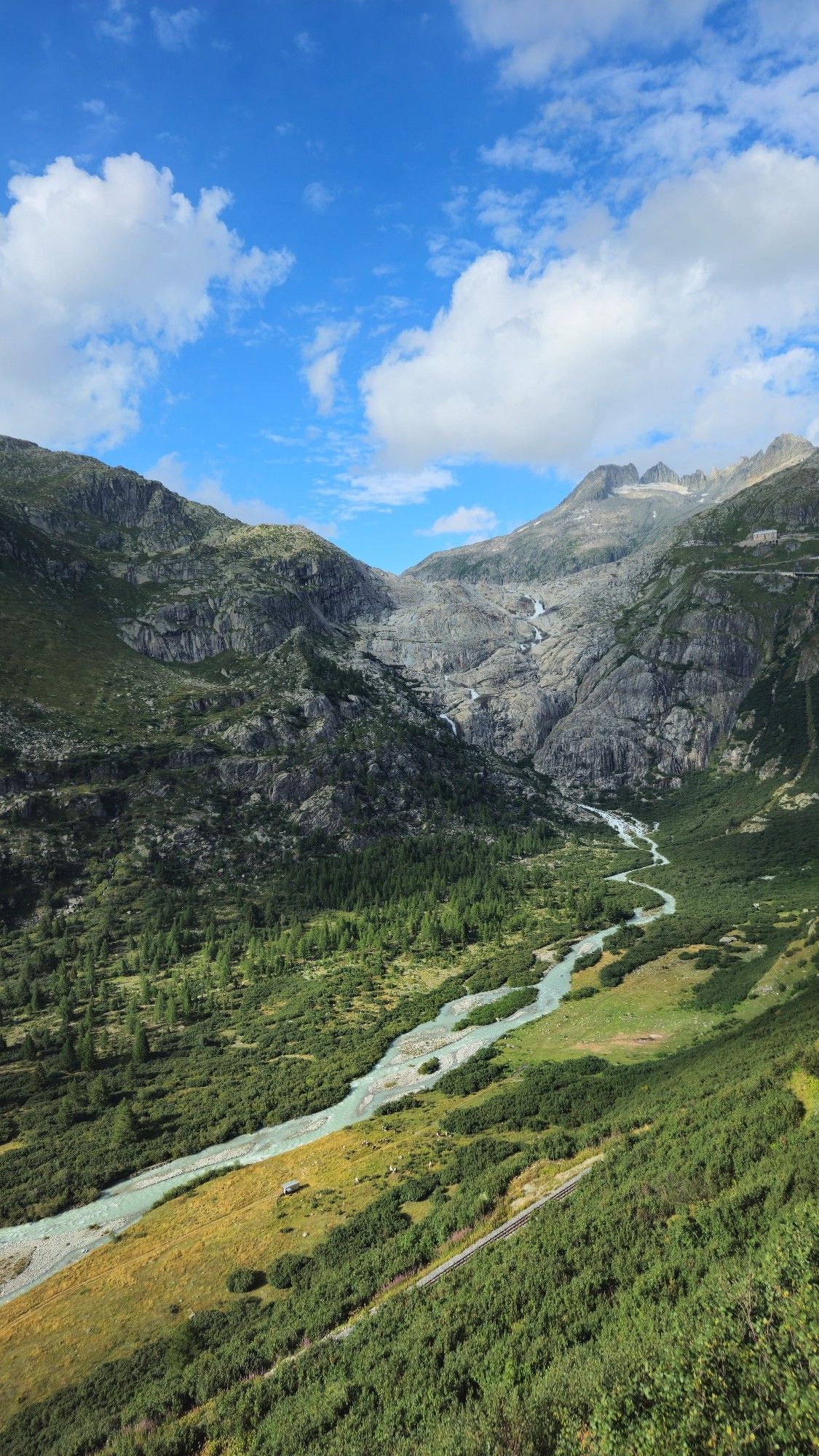 Blick auf das Tal und den Fluss (Rhone) der aus dem Rest des Rhonegletscher und See am Fels das Bergmassiv herab fließt.