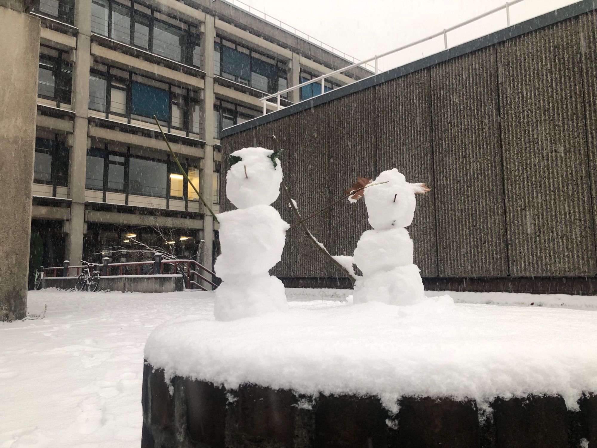 zwei schneepersonen vor gebäude 25