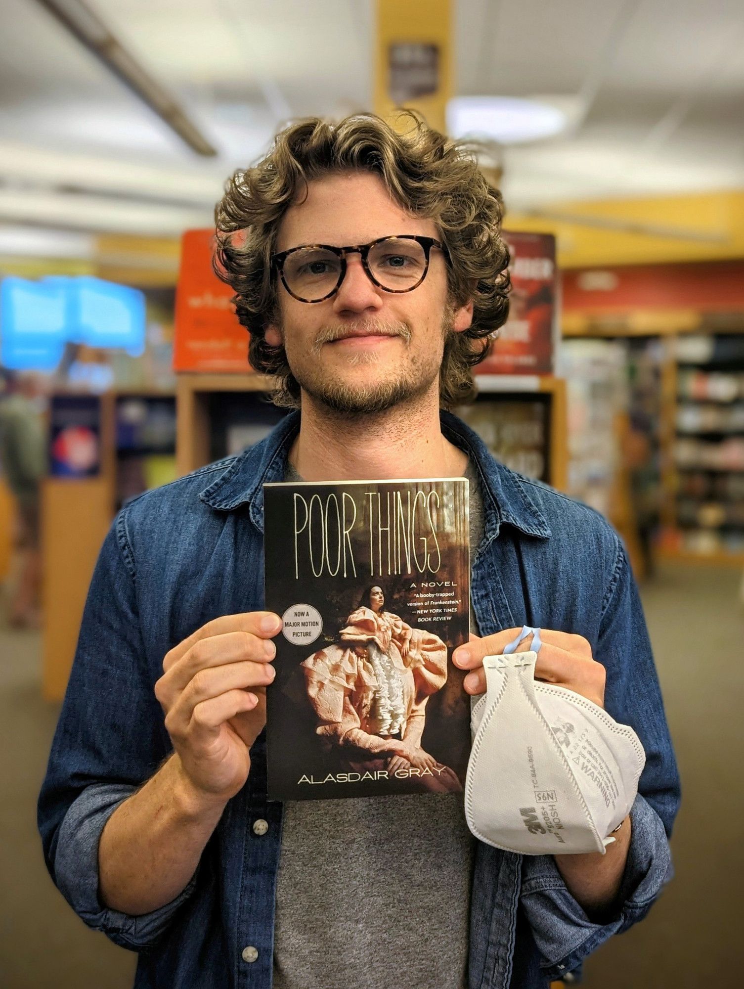 photo of me, a blonde white dude holding up the book "Poor Things" by Alasdair Gray, featuring Emma Stone on the cover, who is starring in the upcoming film adaptation.