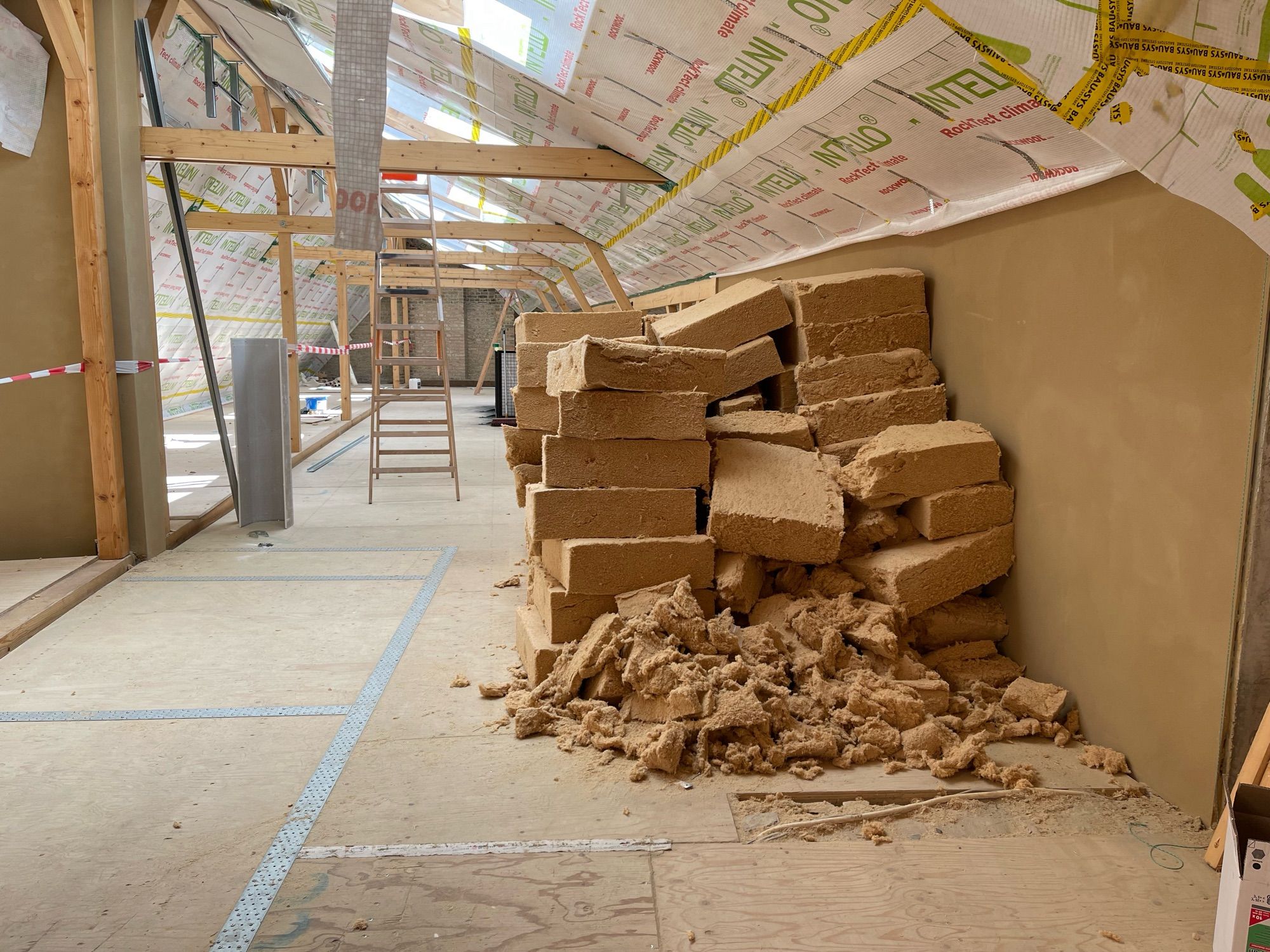 Wood fiber insulation batts stacked in a loose pile