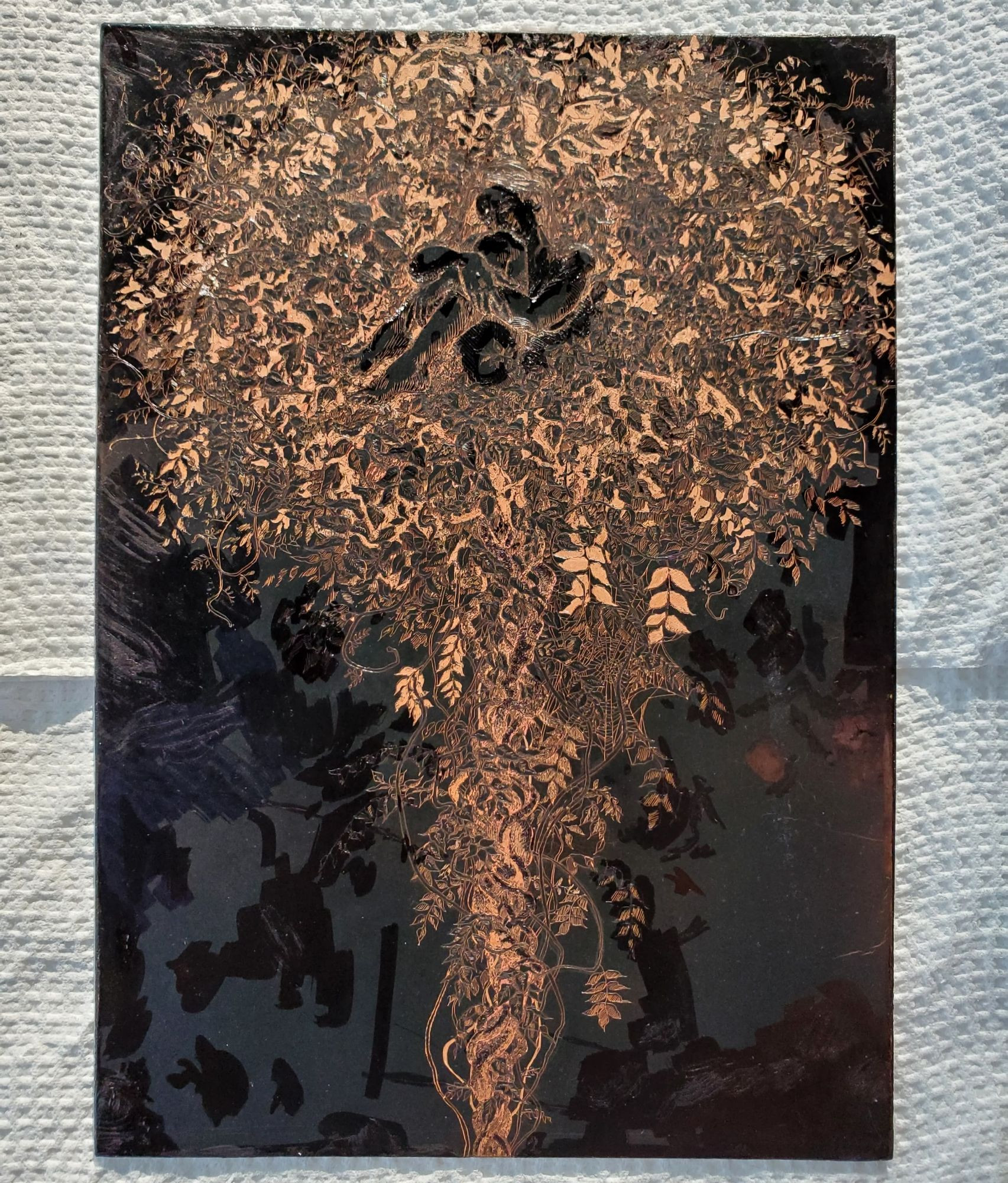 Photo of the final stage of the copper etching before the hard ground was removed to be printed. The image, shown in bright copper against a dark ground, depicts a dense mass of wisteria vines growing upwards with a figure curled up within.