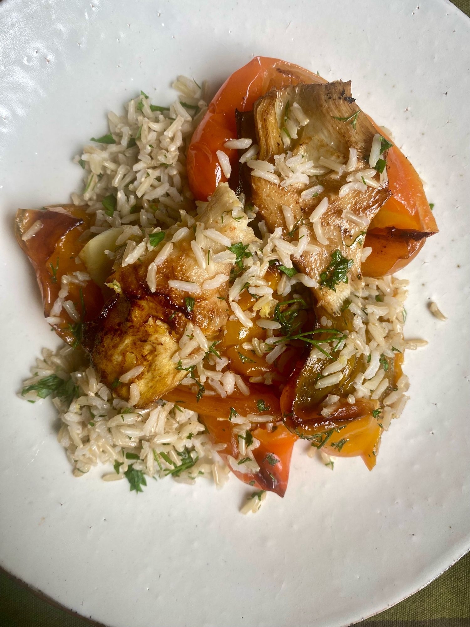 Roast orange peppers, basmati rice and artichokes on a white plate.