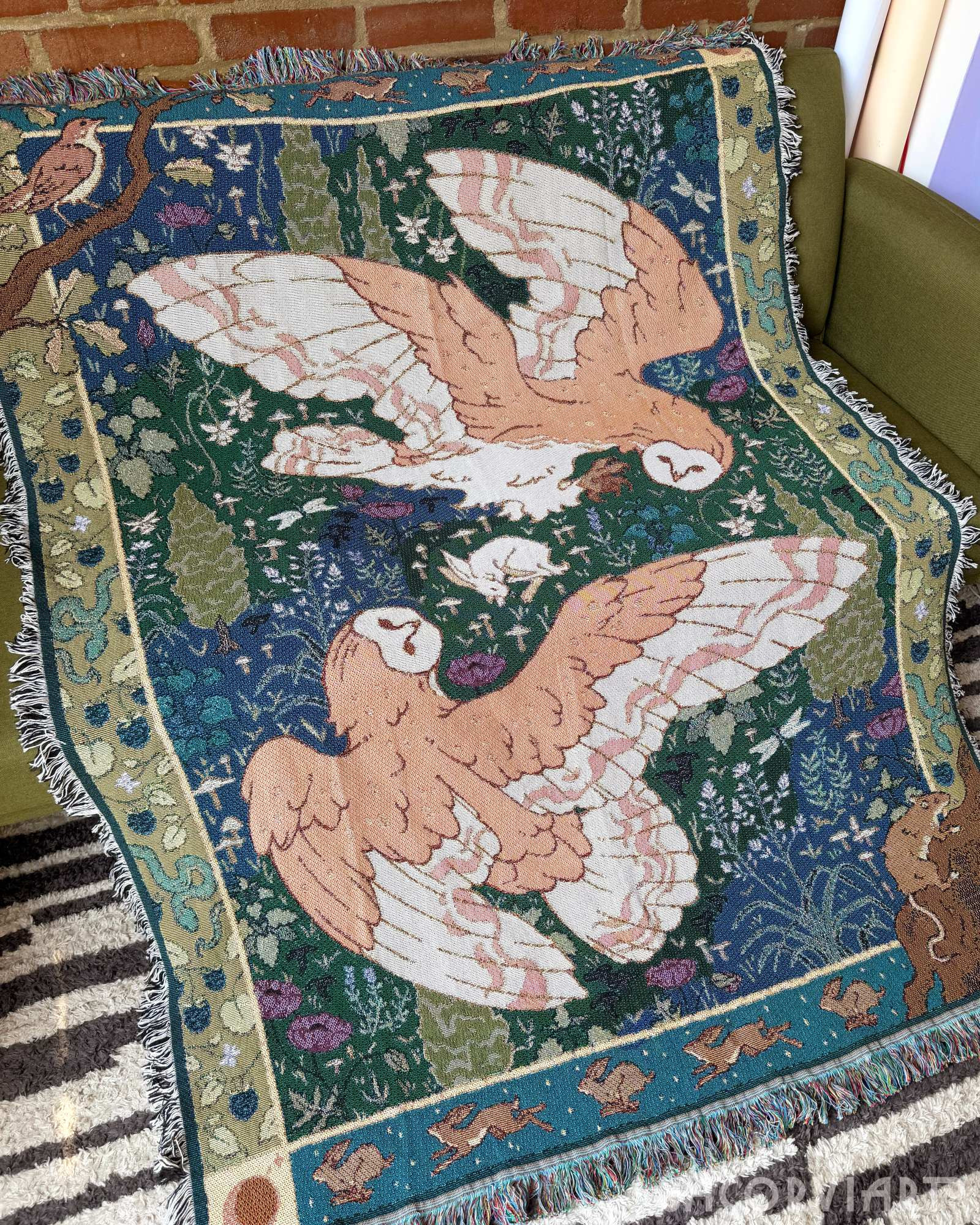 The barn owl tapestry draped over a couch.
