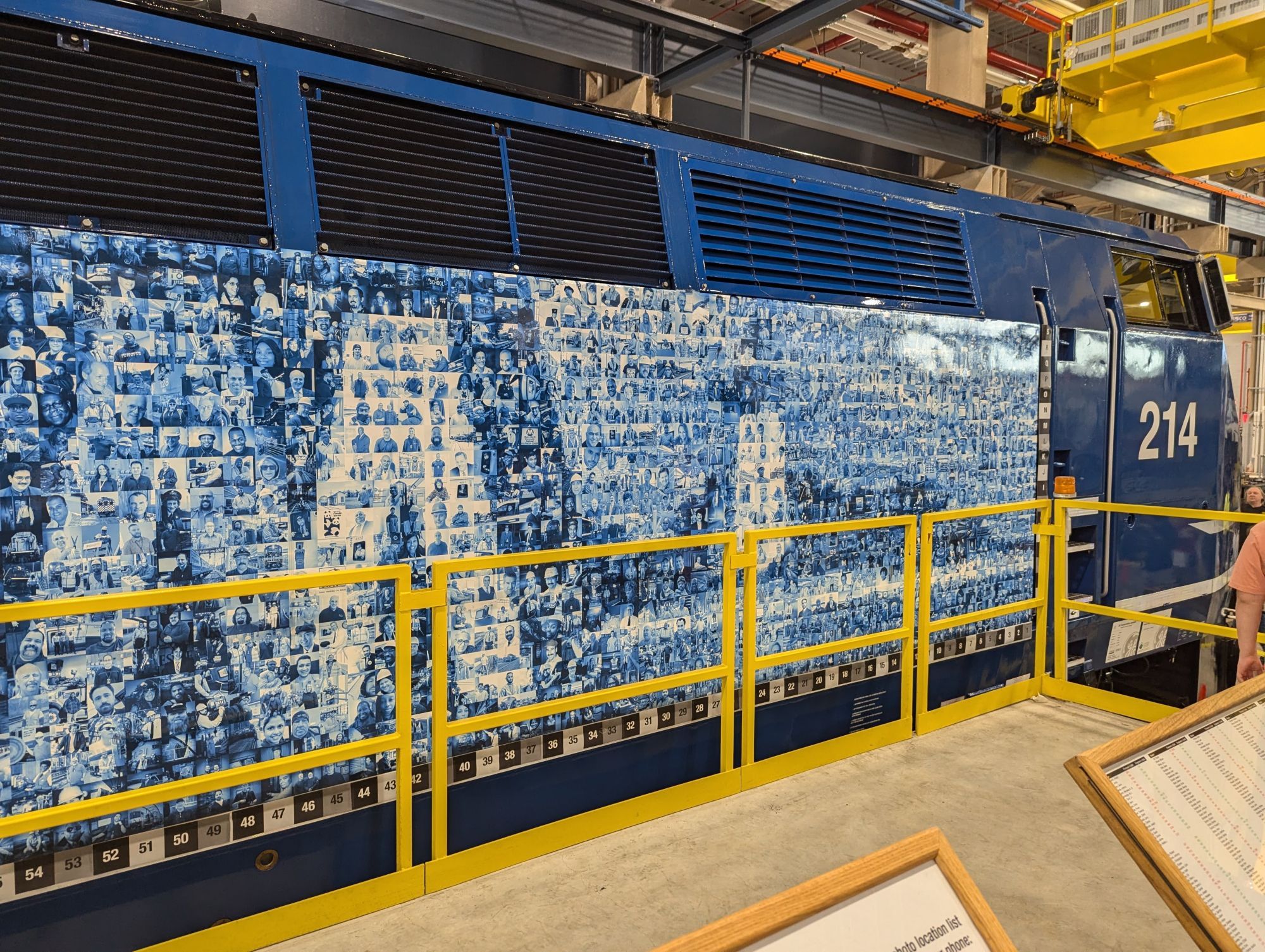 Side view of Metro-North GE P32AC-DM number 214, showing the hundreds of employee photos that make up the side graphics on the locomotive.