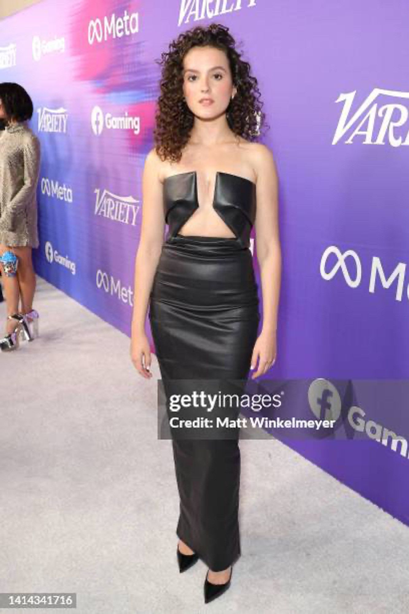 Fina Strazza promotes #PaperGirls dressed in a black, strapless dress that exposes her sternum. The dress is identical to the red one worn by Alejandra Viallarreal at the VMAs.