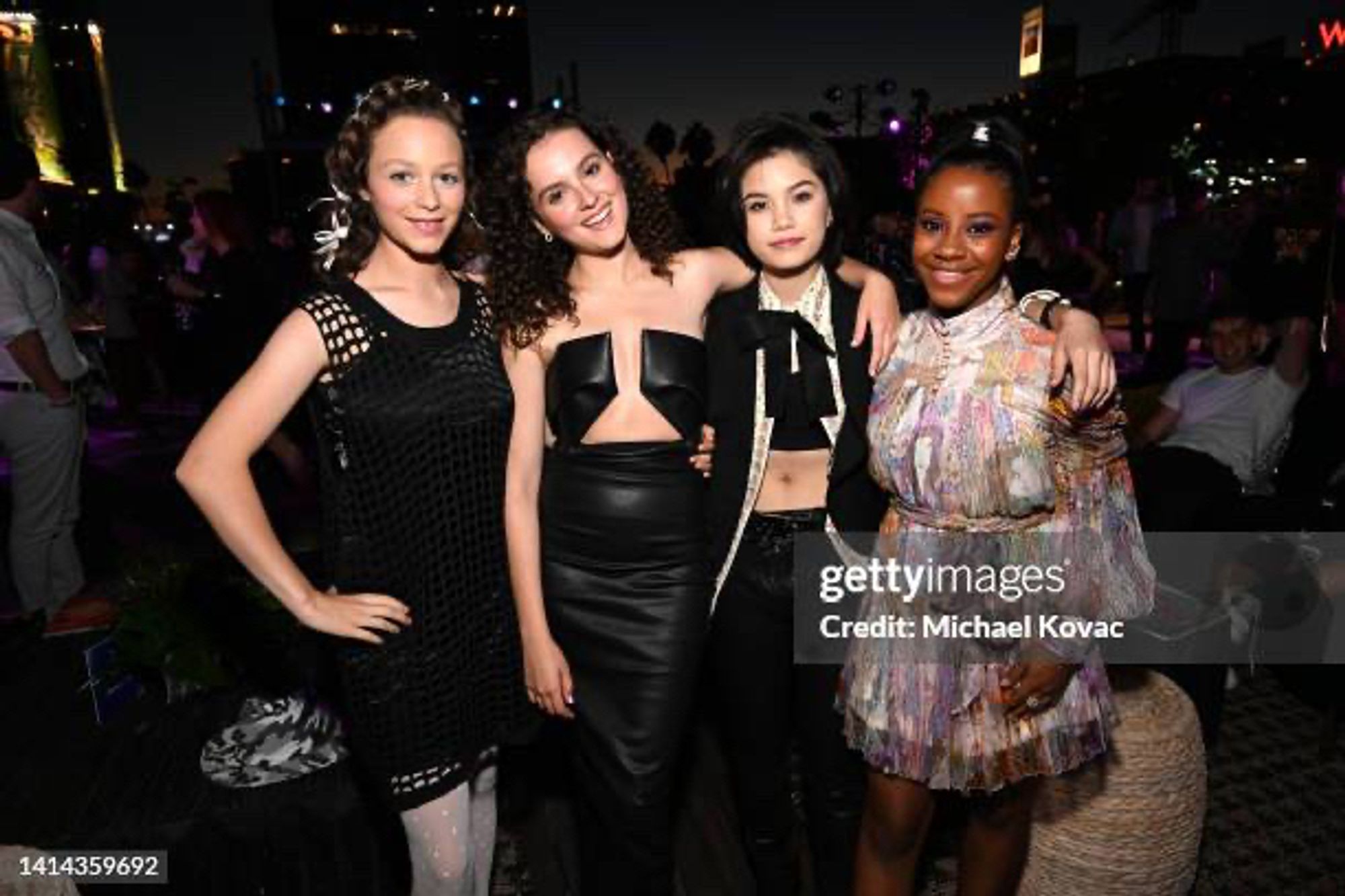 The main cast of Paper Girls promoting the show. From left to right: Sofia Rosinsky (Mac Coyle), Fina Strazza (KJ Brandman), Riley Lai Nelet (Erin Tieng), Camryn Jones (Tiff Quilkin). Fina wears a black, strapless dress that exposes her sternum. The dress is identical to the red one worn by Alejandra Viallarreal at the VMAs. #KajeMac