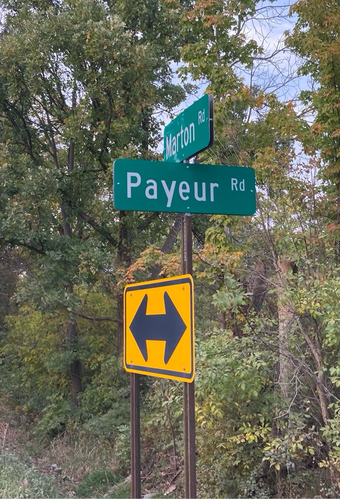 A white-on-green street sign reading “Payeur Rd.”