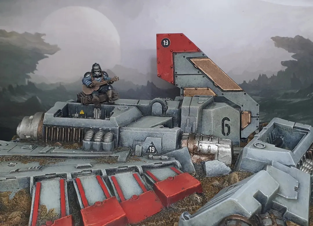 A crashed Aquila Lander with a Krieger sitting on the fuselage, playing guitar