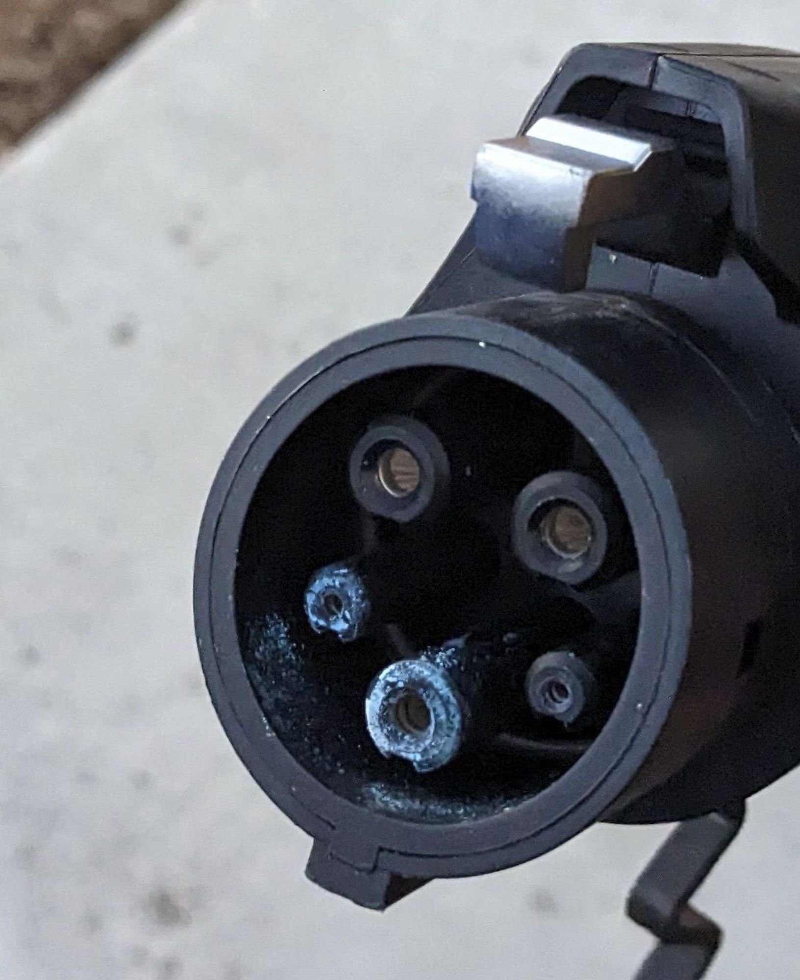 J1772 EVSE plug showing blue fuzzy corrosion around the ground and signal contacts. Probably caused by rainwater containing sulfuric acid getting trapped inside the protective cap