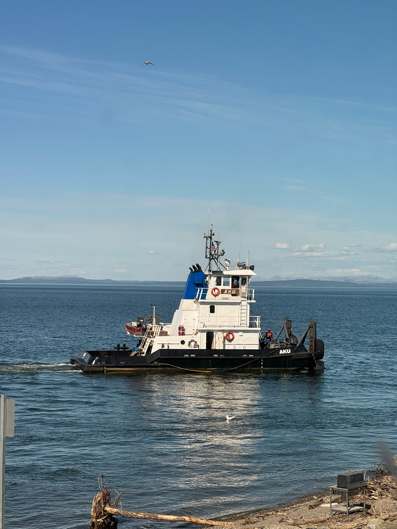 Tugboat Aku approaching the dock in Kotzebue Sound during the day.