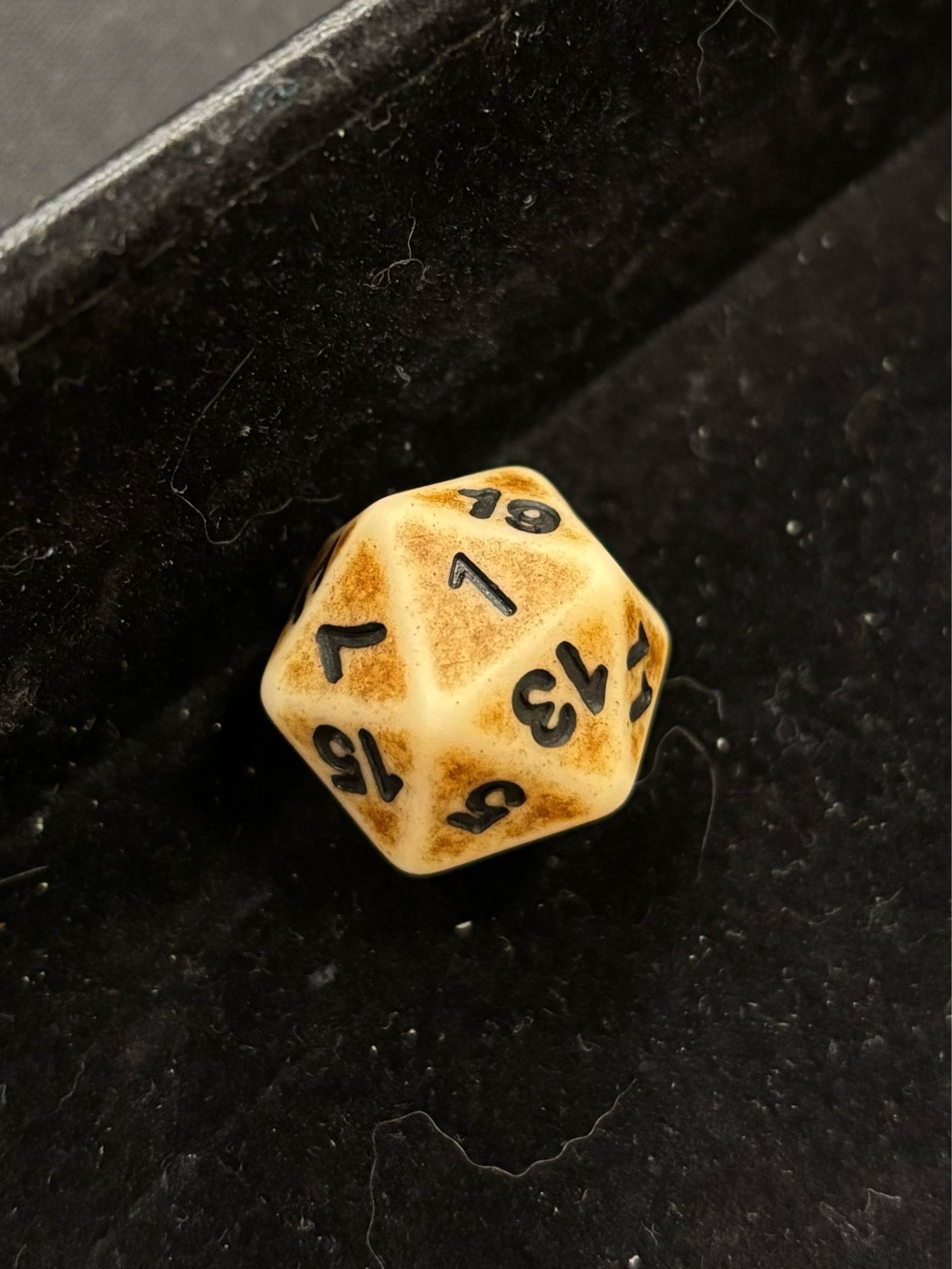 A 20-sided die with the "1" face up.