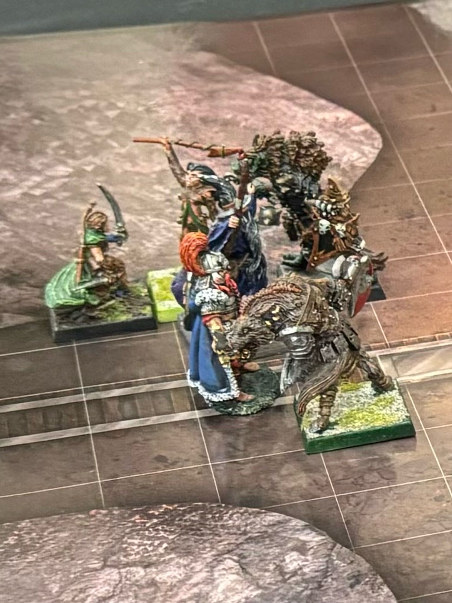 Miniatures representing a group of heroes fighting some gnolls on a gridded battlemap.