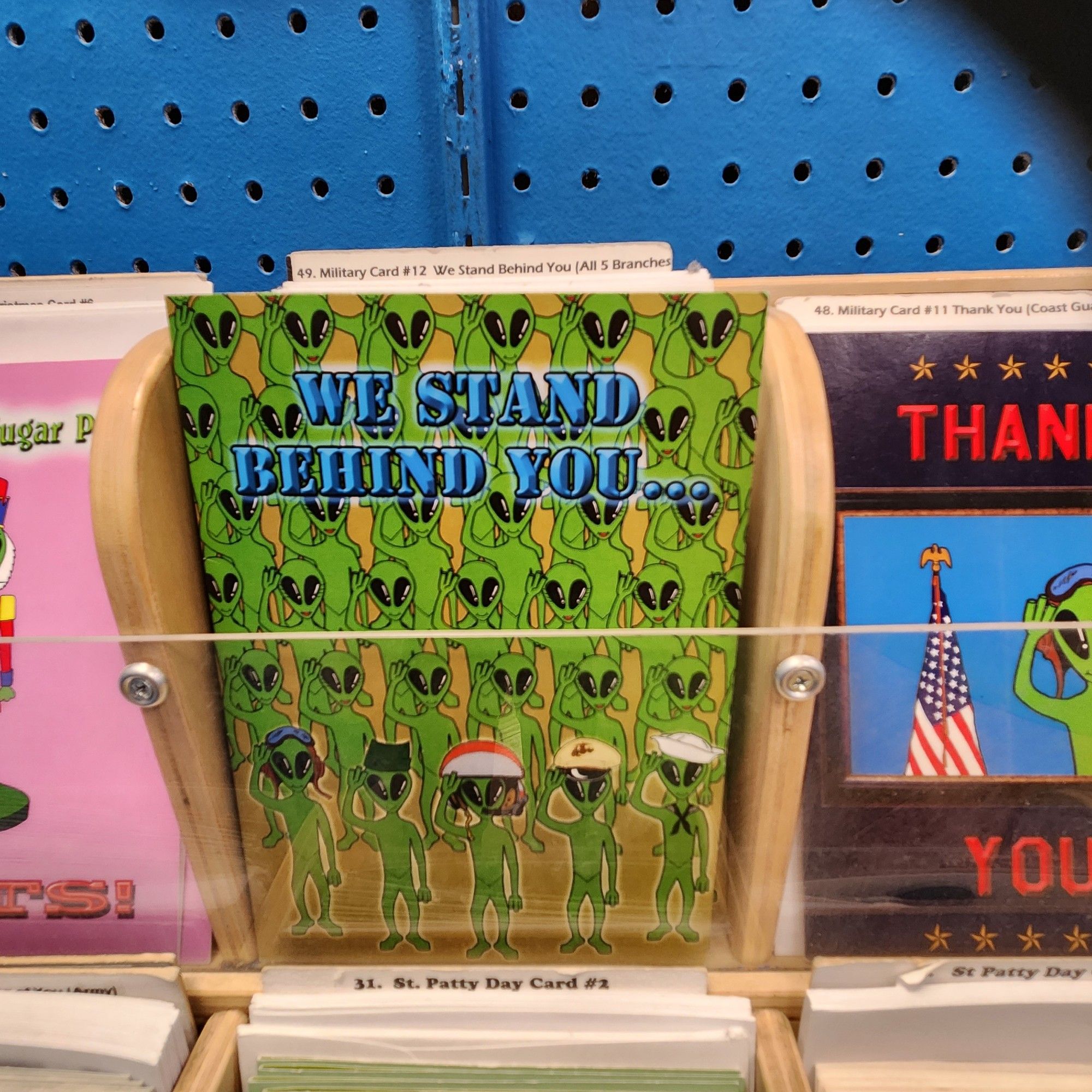 A greeting card with aliens dressed as all branches of the American forces. It reads "we stand behind you"