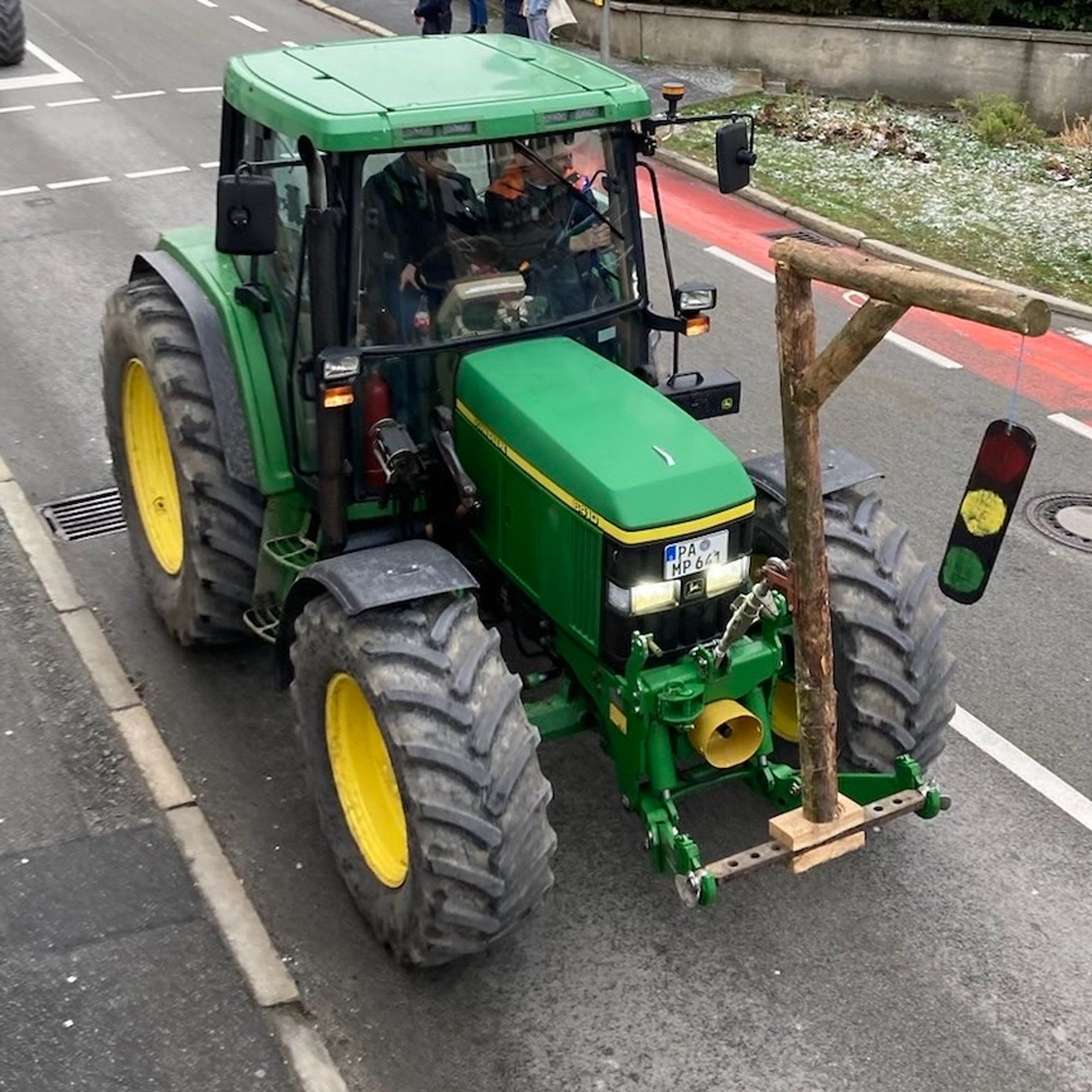 Traktor der statt Frontschaufel einen selbstgebauten Galgen montiert hat an dem eine Ampel baumelt.
Bild: Zusendung, privat