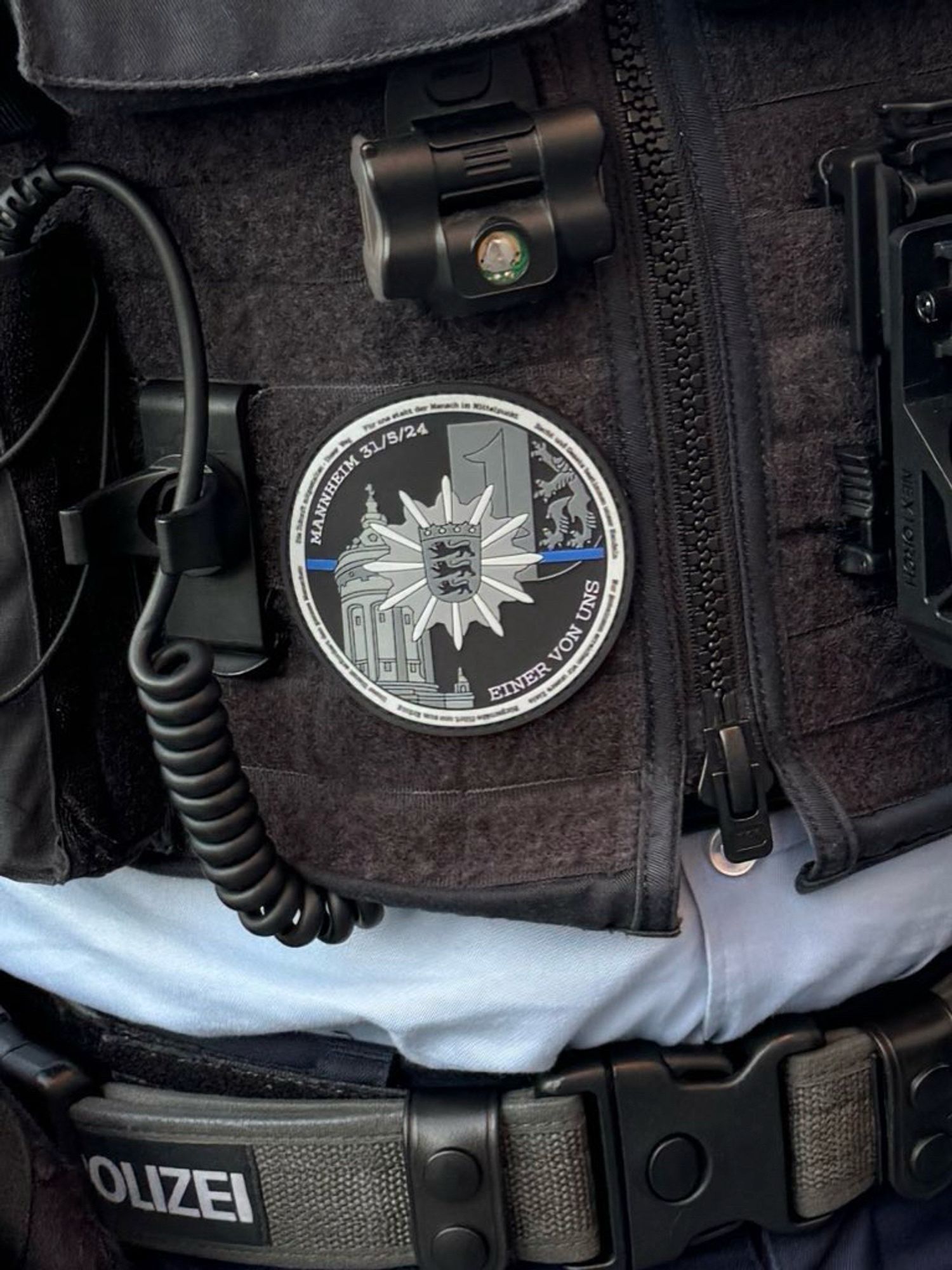 Patch "Einer von uns" rund mit Polizeistern BaWü und ThinBlueLine an der Weste eines Bundespolizisten