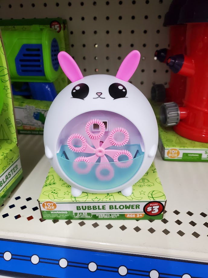 Picture of a bunny themed bubble blower. It is very rotund with a white body, bright pink ears, large black eyes and a little pink nose. The belly is inset with a fan blade arranged set of 6 bubble wands that spin and dip into a resevoir of bubble liquid in the bottom half of the belly area.