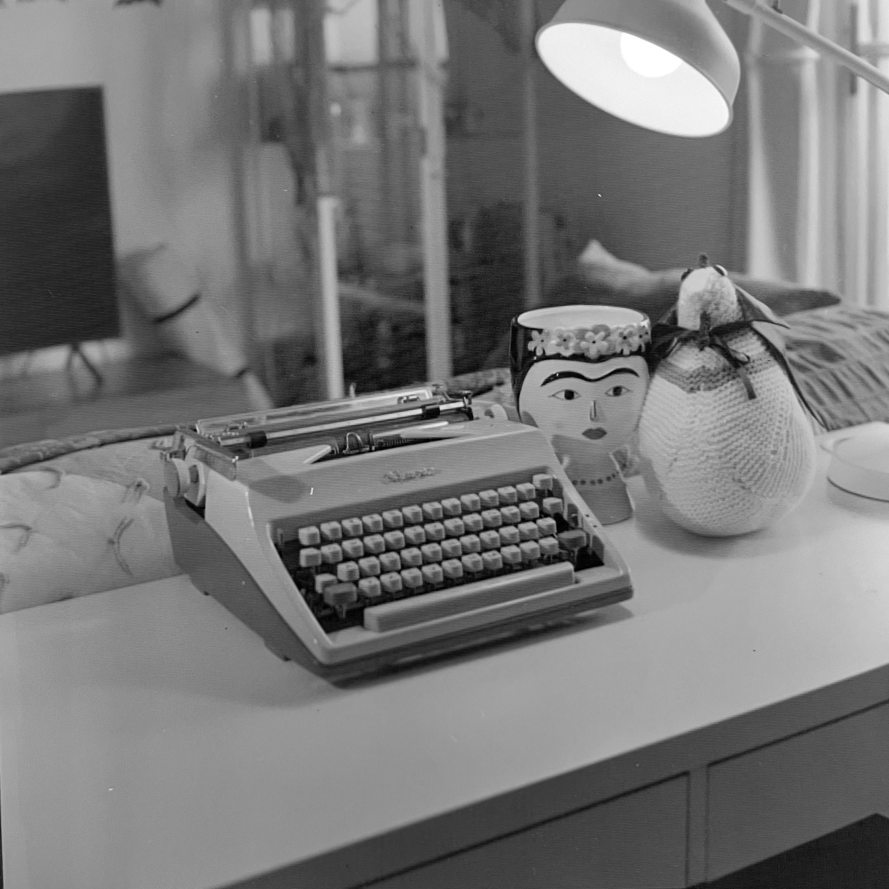 Olympus typewriter on a desk accompanied by a knitted chicken with a cape for Halloween (we call her Camilla, a-la Muppets) and a plant pot resembling Frida Kahlo. 

Since I do not have suitable equipment to scan film of this size, it is not a high-quality photo. It is to illustrate that a roll of film expired 67 years ago still yields a nice image. 