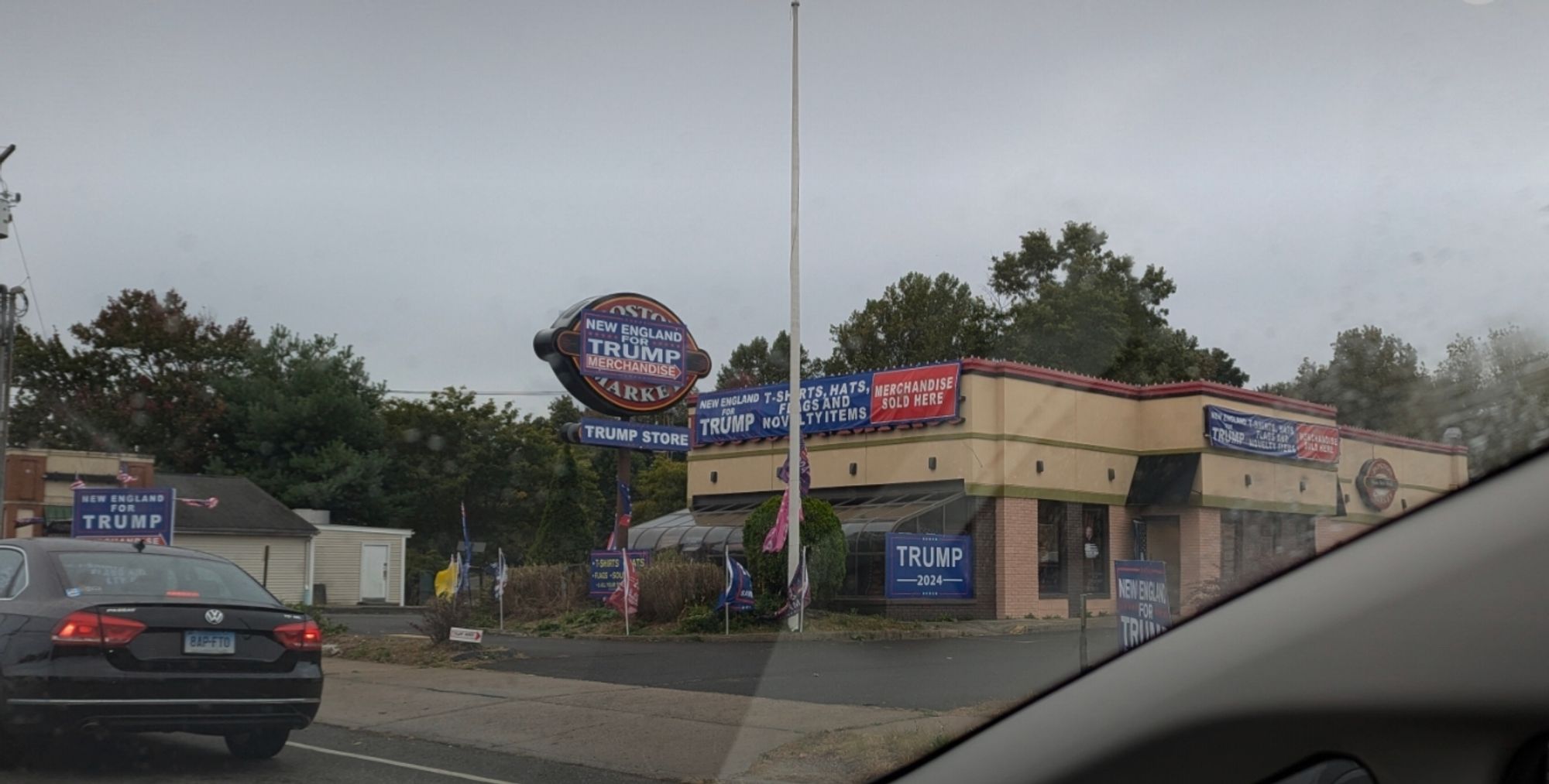 Picture of a Trump Store at the site of a former Boston Market. Temporary Trump 2024 signs are imperfectly posted over the Boston Market logo