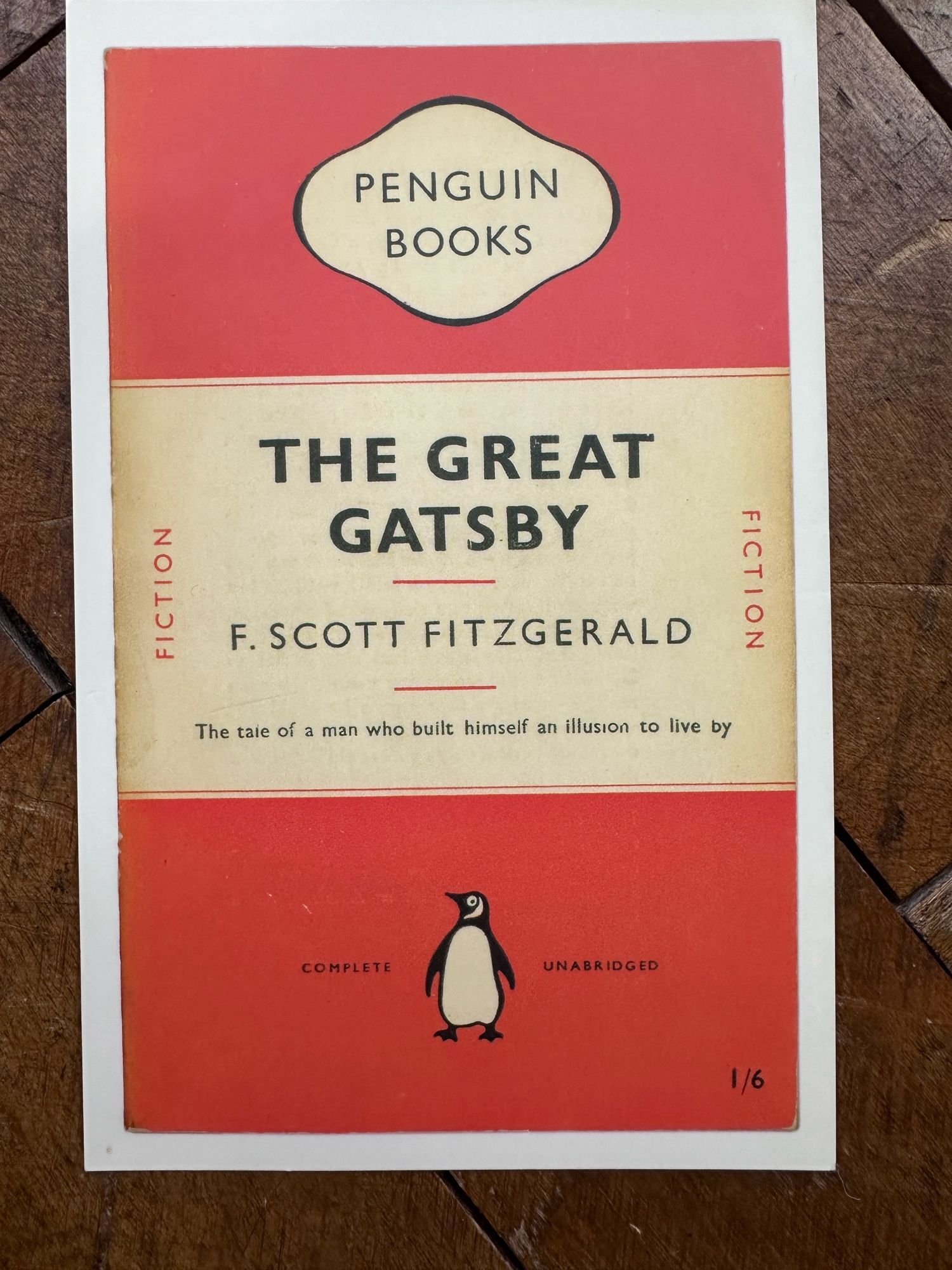 Penguin 1950 edition of The Great Gatsby in the classic orange livery, with the tagline on the cover “The tale of a man who built himself an illusion to live by”.