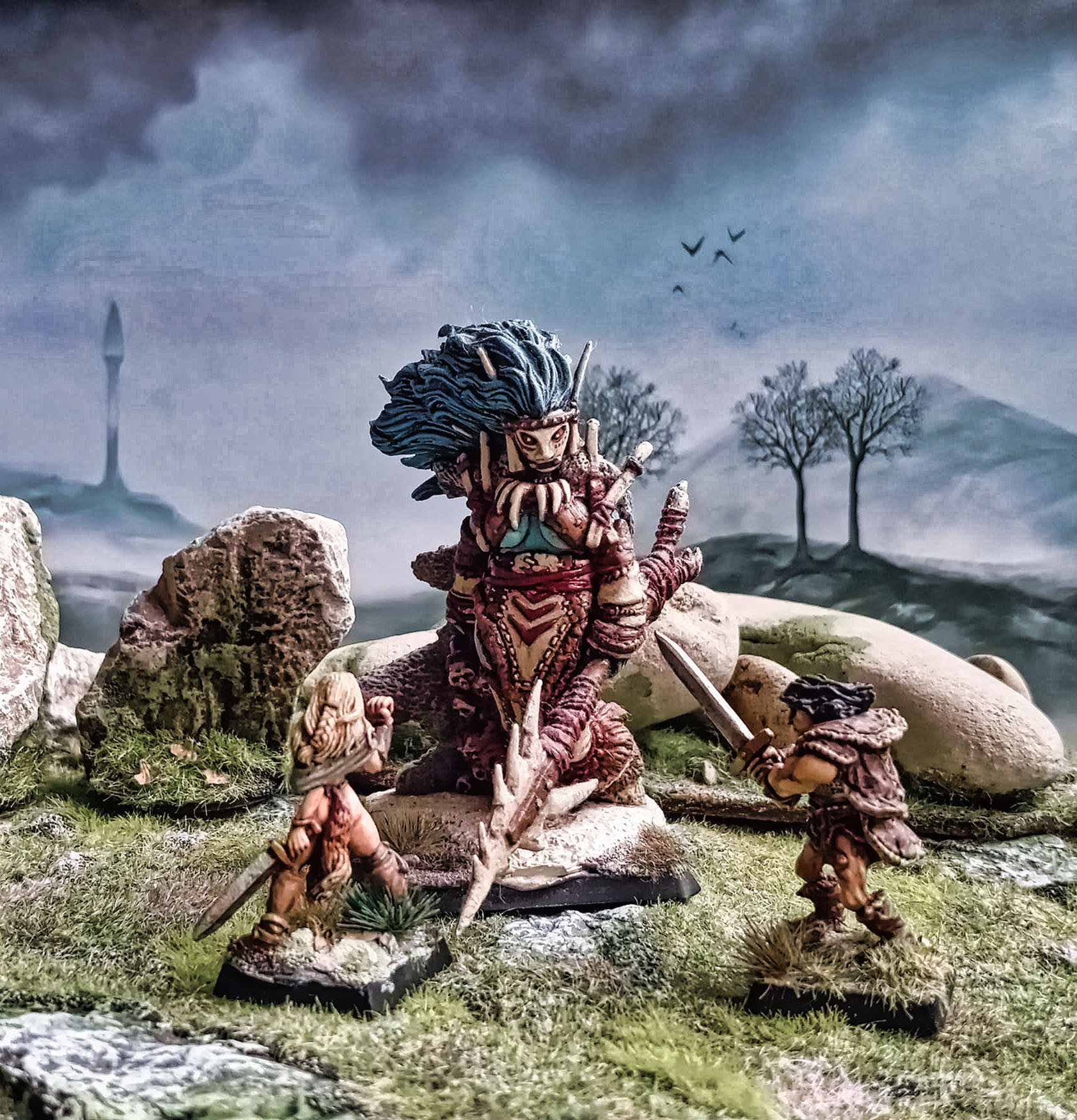 A blue ice gigantess facing a couple of barbarians. 28mm miniatures.