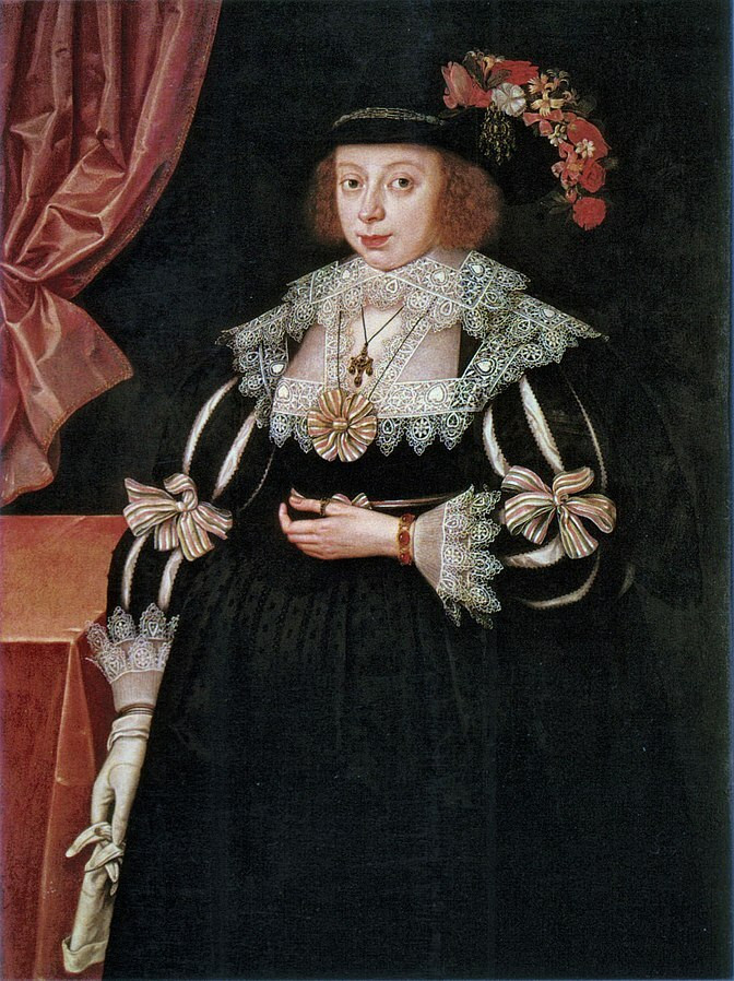 Portrait of a woman in a black dress with decorated sleeves, black hat with red flowers, and white lace ruff.