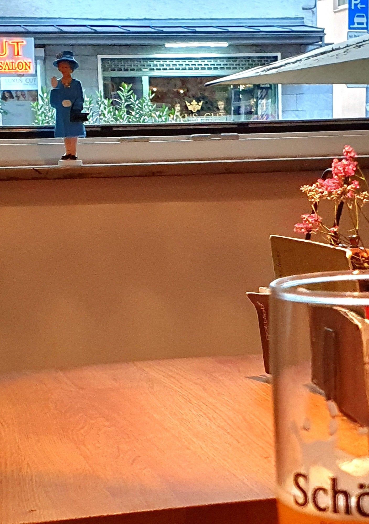 2 Fotos aus einem Café - einmal mit kleiner Figur der Queen auf der Fensterbank - einmal mit einem Tisch mit griech. Salat und Gemüse suf Brot