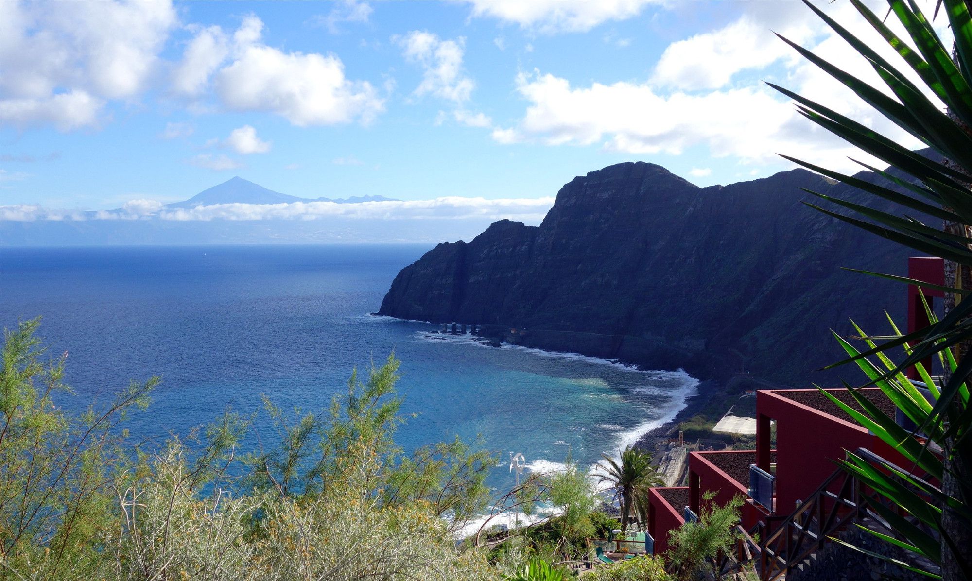 zweimal im Vordergrund Berge und Meeresbucht - im Hintergrund die Silhouette von Teneriffa mit der Bergspitze des Teide