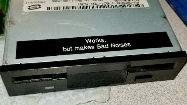 Label on CD/DVD drive reads “Works, but makes sad noises.”