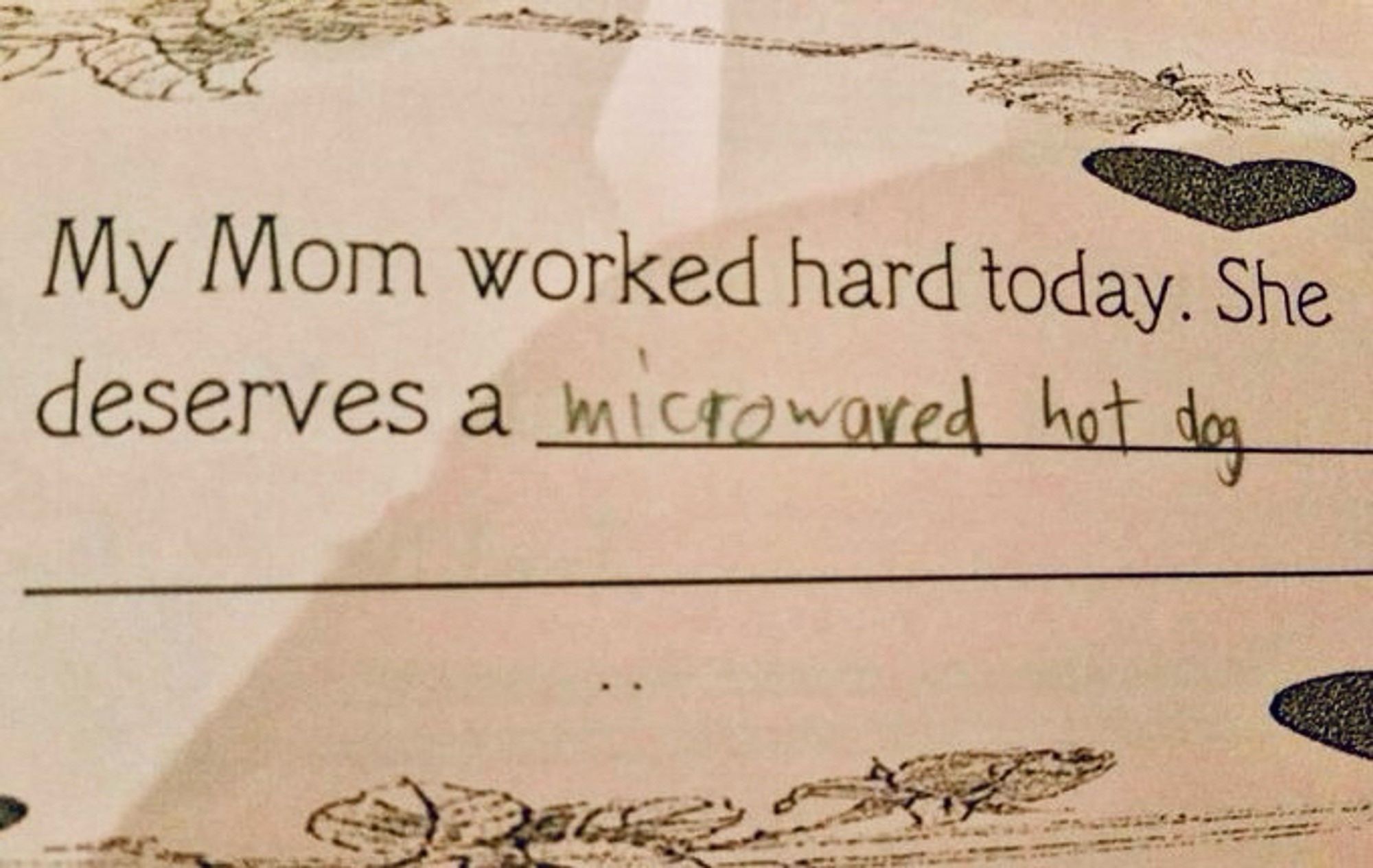 School project/form reads “My Mom worked hard today. She deserves a __________” filled in with “microwaved hot dog.”