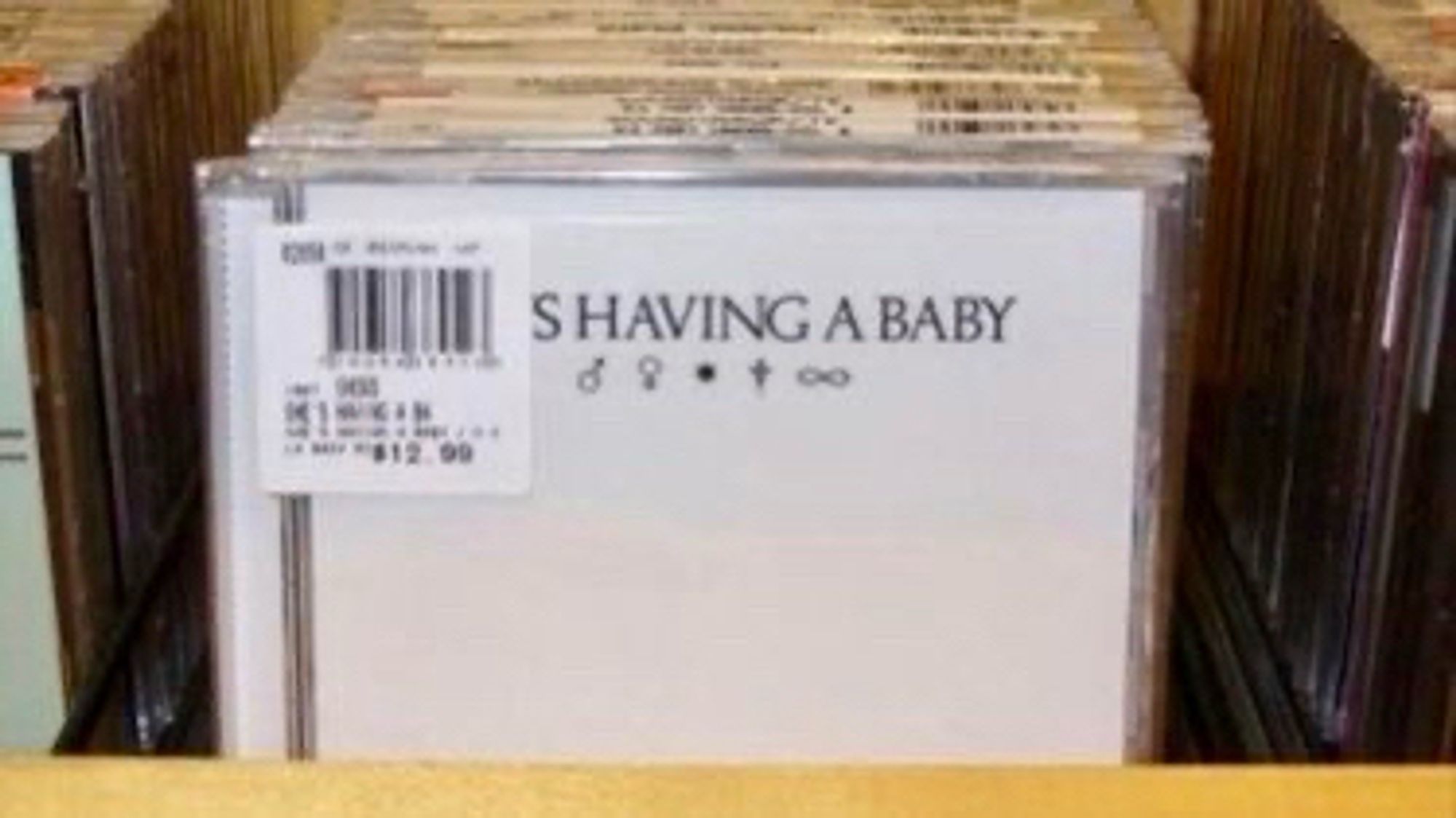 Soundtrack CD of “She’s Having a Baby” with price sticker partially covering the title making it appear to read “SHAVING A BABY.”