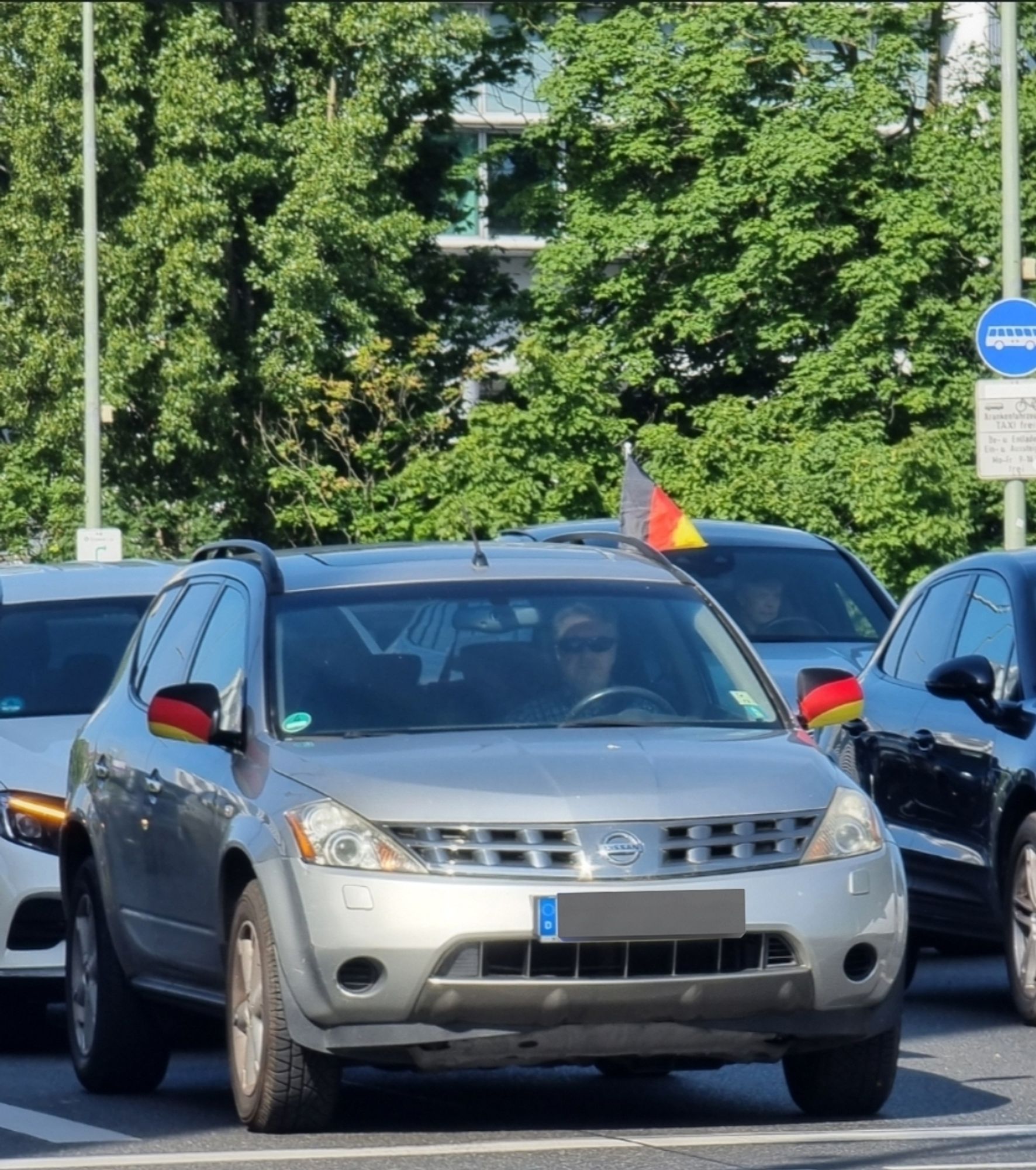 Auto mit Deutschland Fähnchen und Schwarz Rot Gold Kondome über den Außenspiegeln.