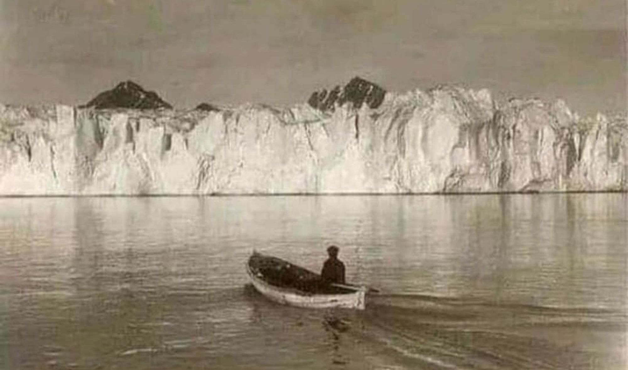 Schwarz Weiß Bild aus Spitzbergen von 1928,Fischerboot vor einem massiven Gletscher