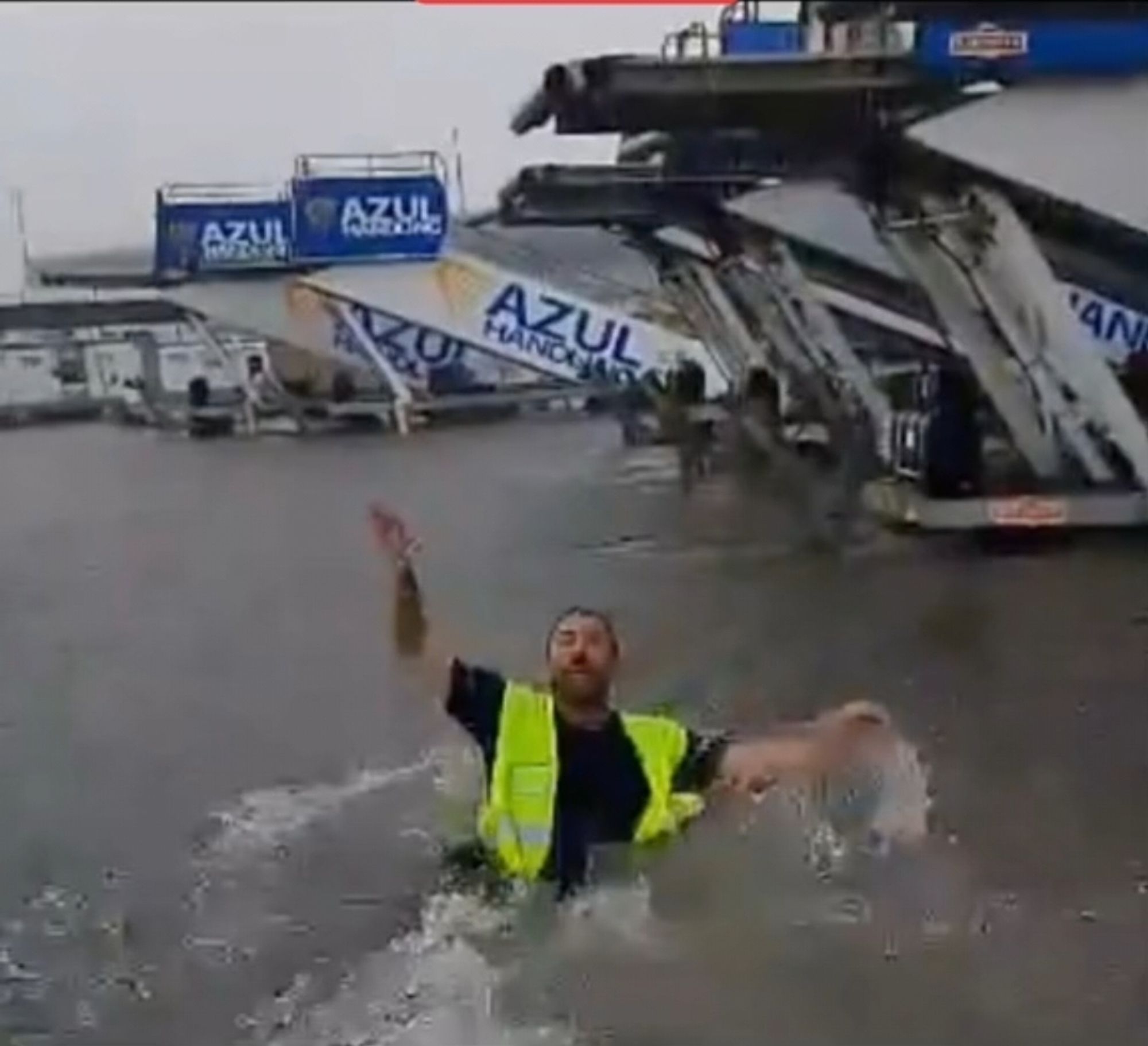 Ein Flughafen Mitarbeiter steht bis zur Hüfte im Wasser auf dem Flughafen in Palma de Mallorca