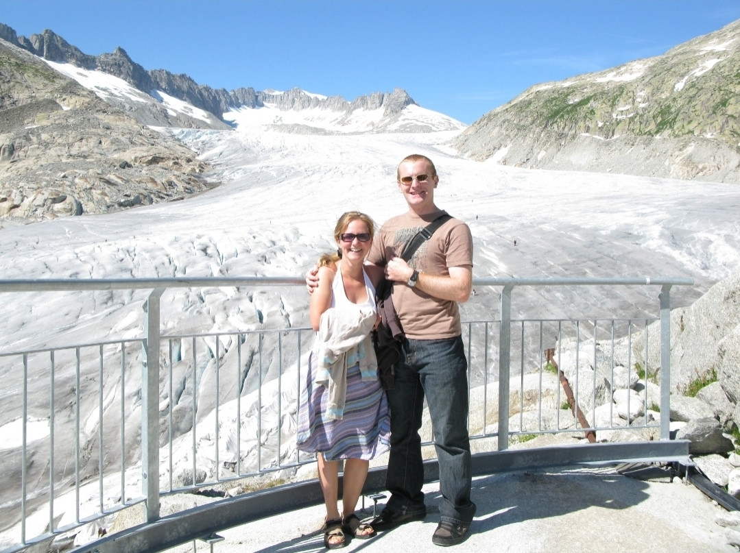 Ein Paar auf einem Aussichtspunkt. Dahinter der riesige Rhonegletscher