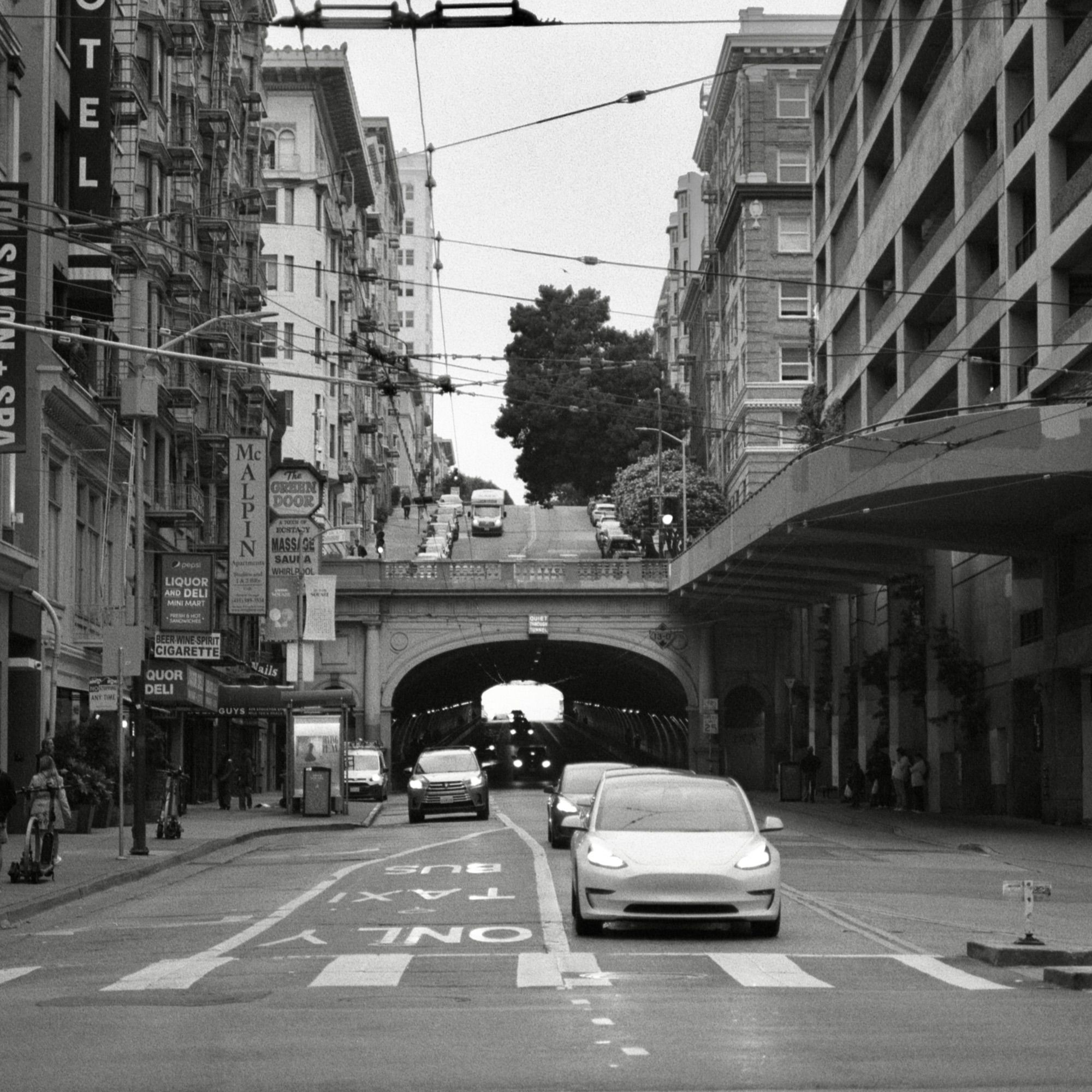 A black and white film photo. The layers of San Francisco, California reveal themselves with streets and a tunnel bookended between buildings. Friday, June 7, 2024.