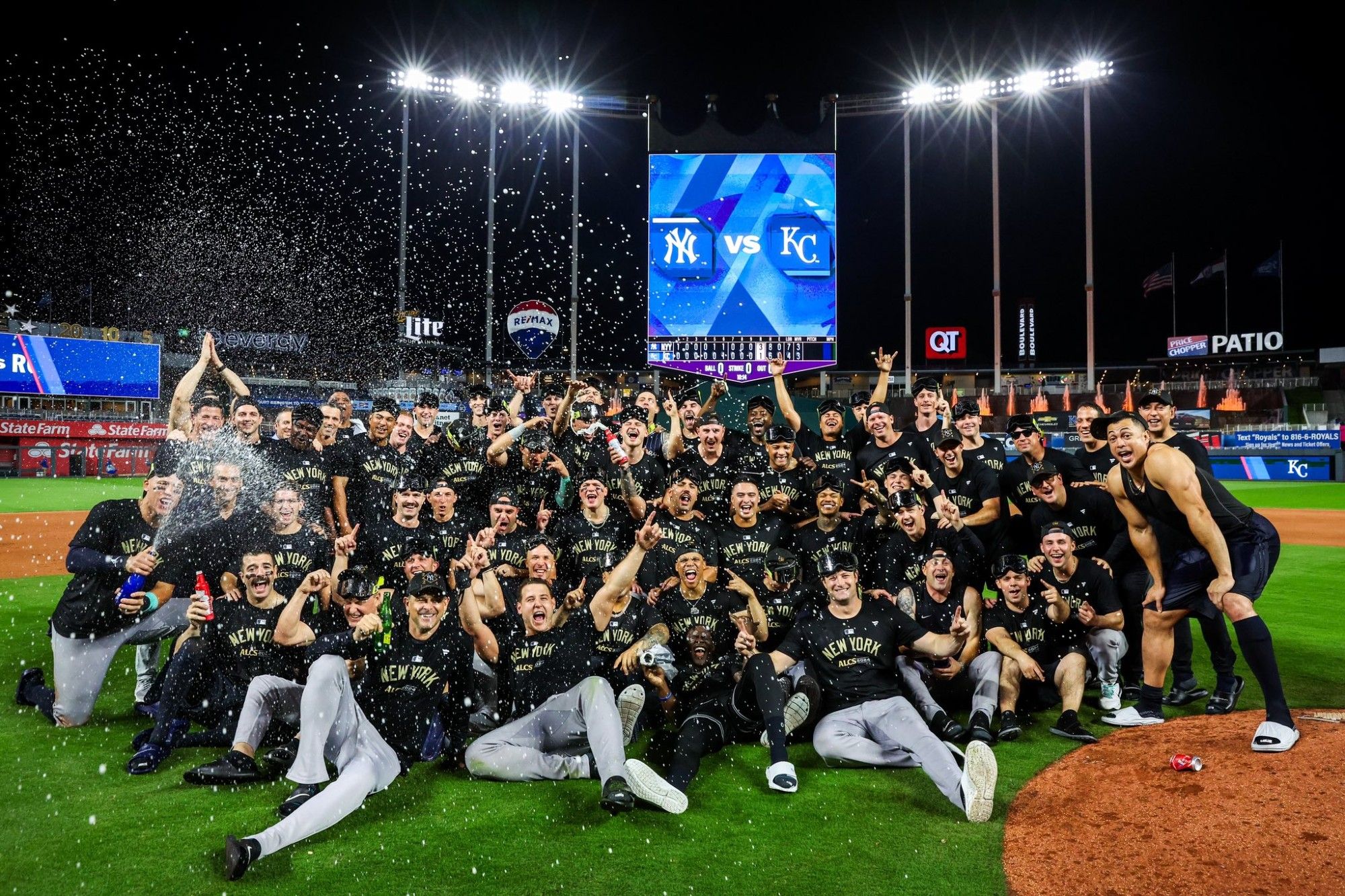 Entire Yankees team celebrating going to the ALCS on the field in KC.