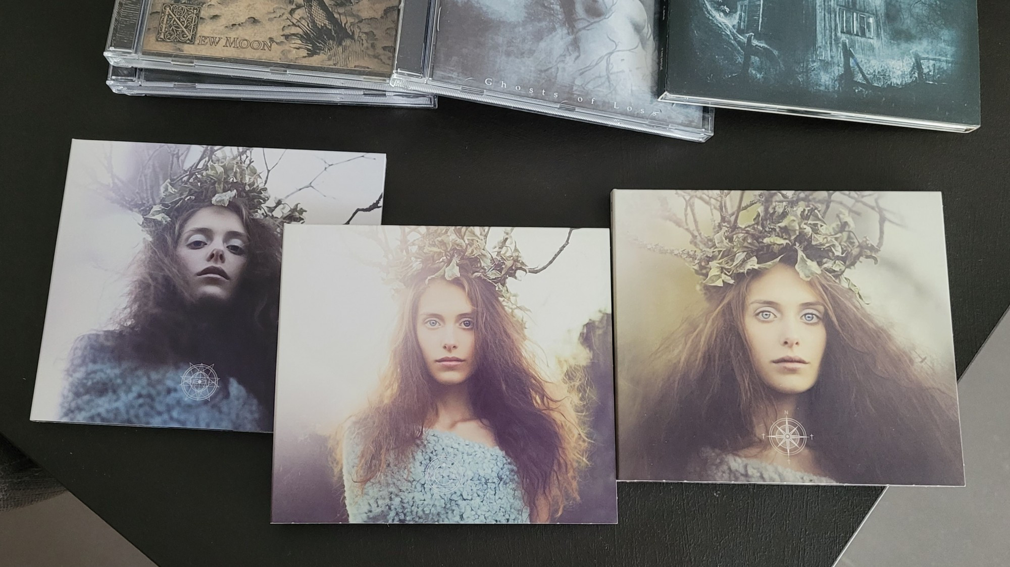 Trois disques de l'album Songs from the North de Swallow the Sun : sur chacun d'entre eux, la photo d'une zouz aux cheveux long en robe et couronne de feuillage