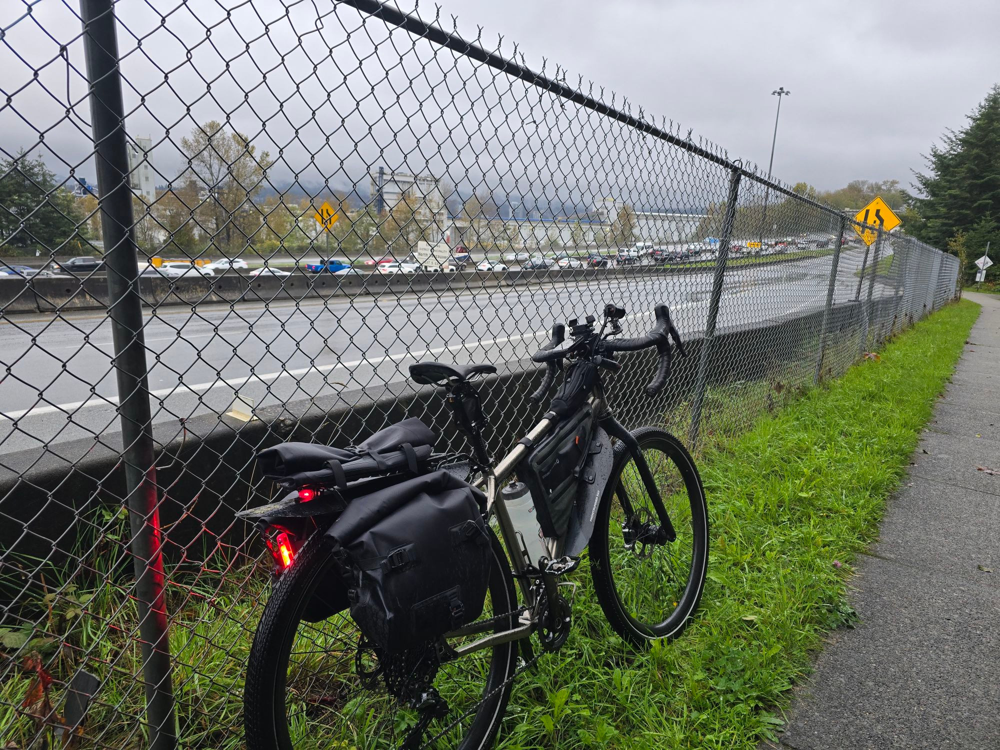 Bike leaning on fence next to the congested Highway #1 over Iron Workers bridge.