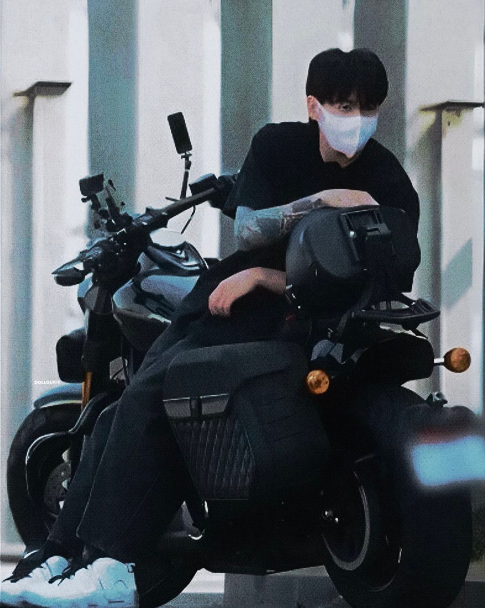 jungkook leaning against a motorcycle with a mask on