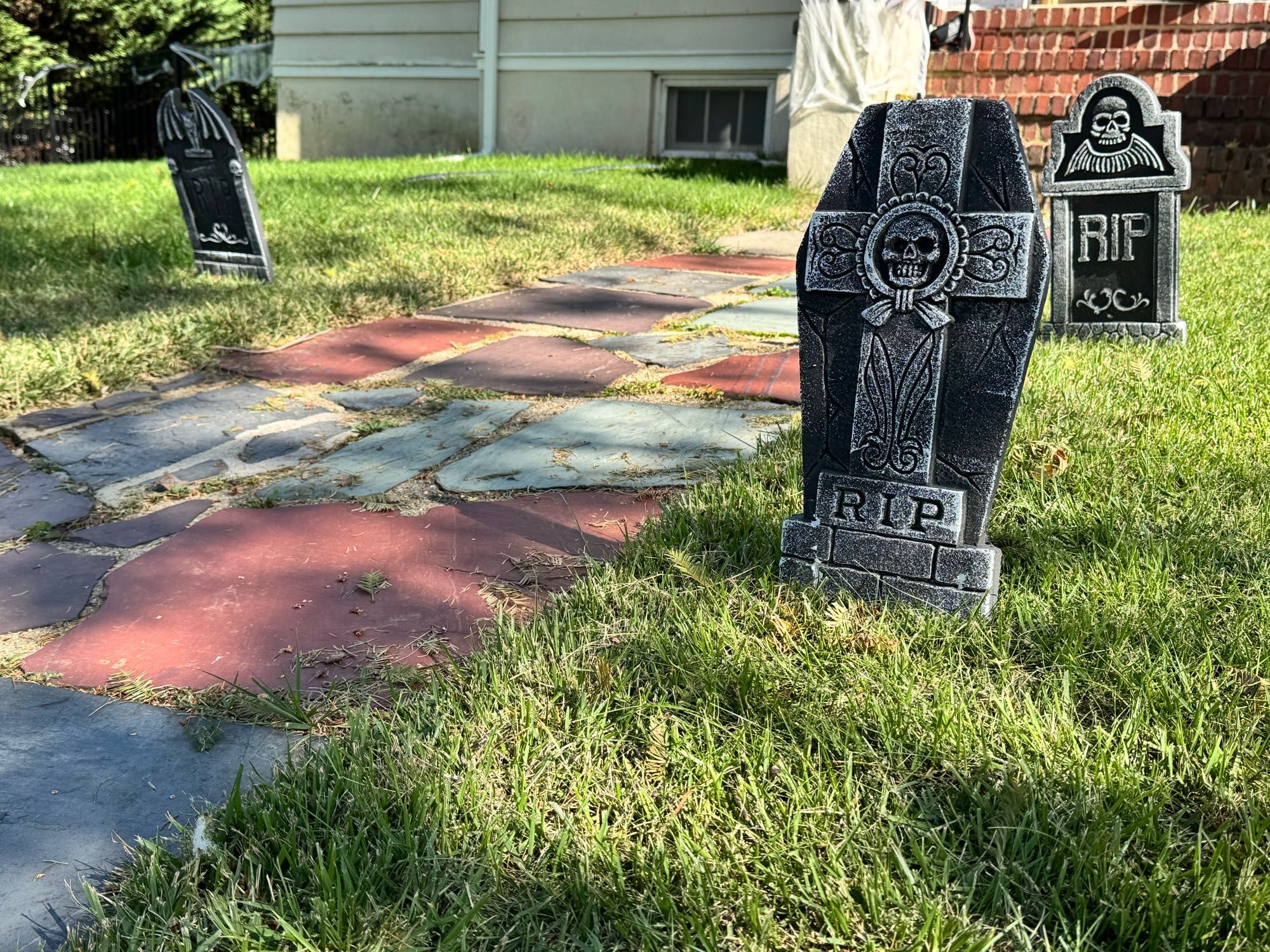 Three headstones, two on the right and one on the left of a walkway