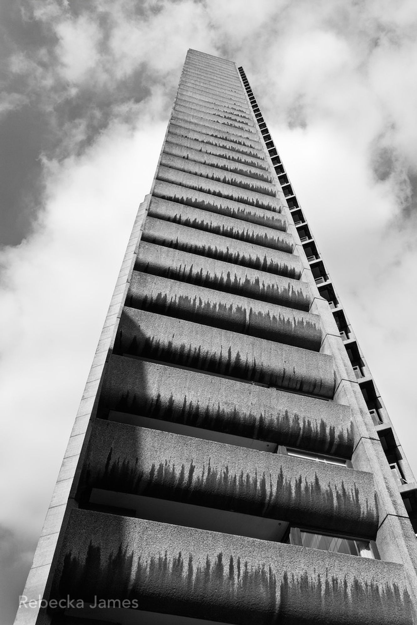 Looking up one side of Cromwell Tower, one of the three tower blocks as part of the brutalist Barbican estate.  This angle is just a column of concrete balconies that fill the width of each floor on the narrow south facing side that cuts off a corner of the triangular building.