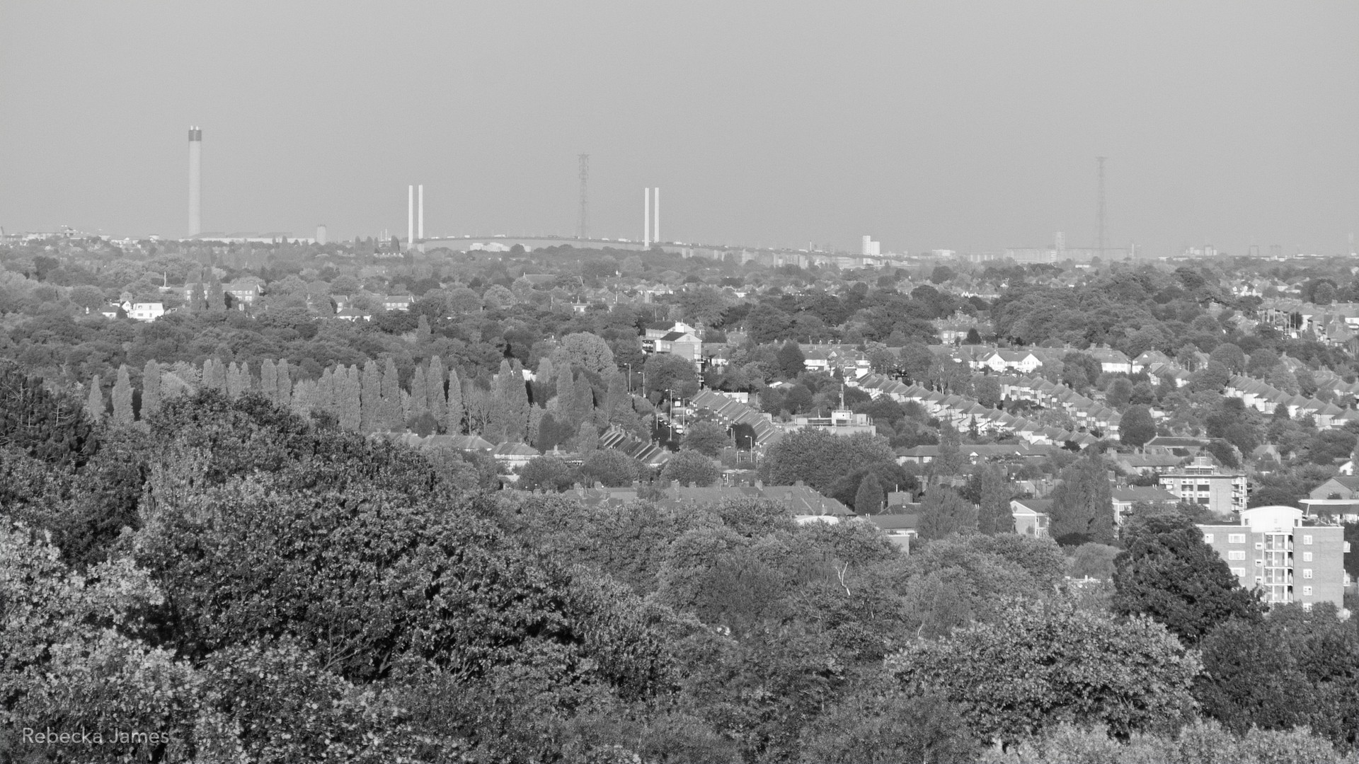 On a clear day, the QEII bridge can be see fifteen miles away from the Norwood Ridge in Crystal Place.  In between houses can be seen amongst the many trees of the London’s south-eastern suburbs.