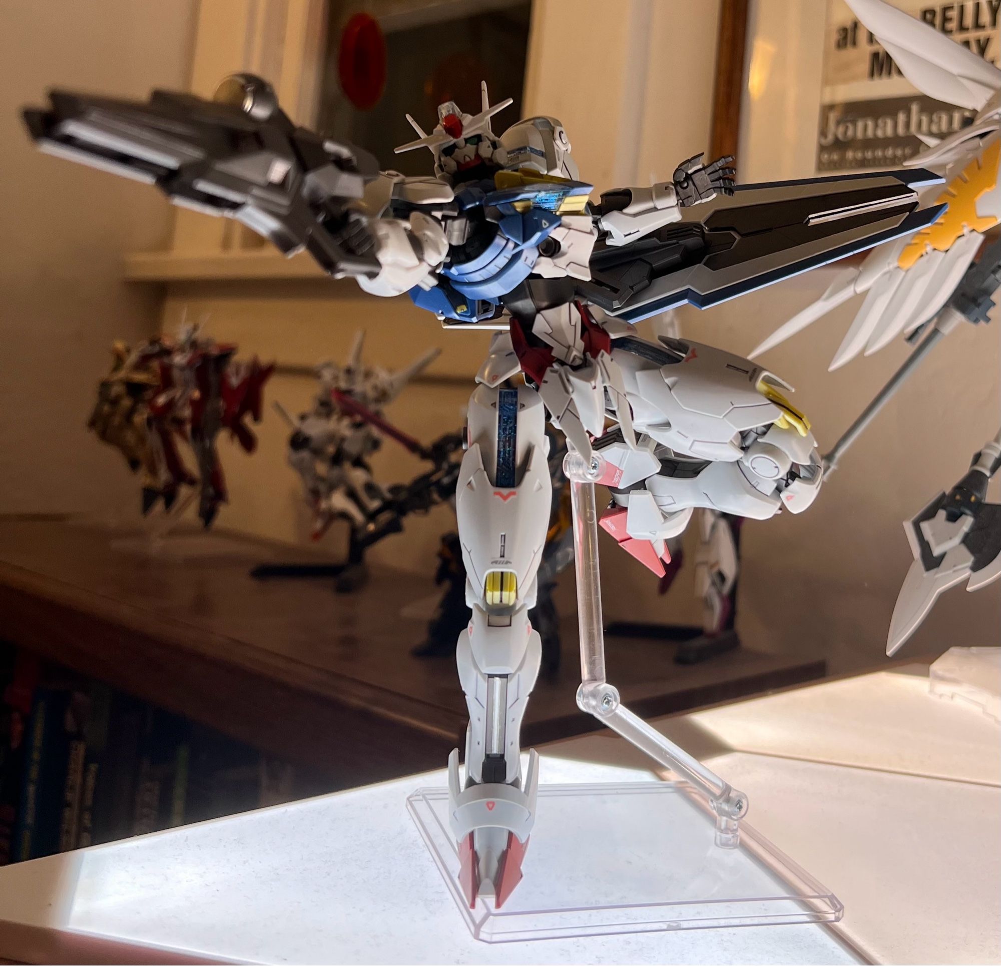 A gunpla model of Gundam Aerial in a shooting pose, dramatically lit from below