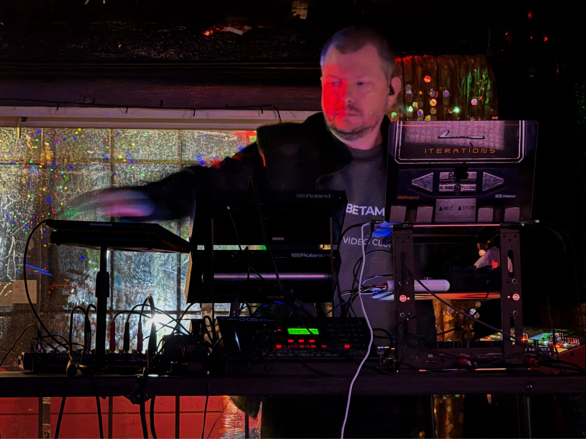 Synthwave artist Iterations performing at Slash Run in DC. He is partially obscured by his laptop and mixing equipment.