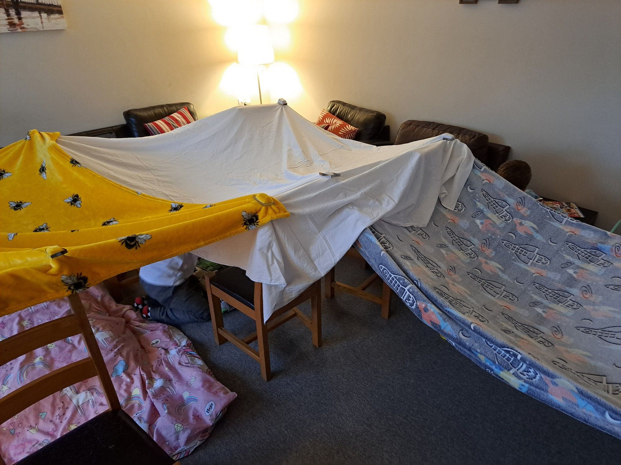 A den built with 6 chairs, 1 sideboard, two blankets, one sheet and some (now) happy kids.