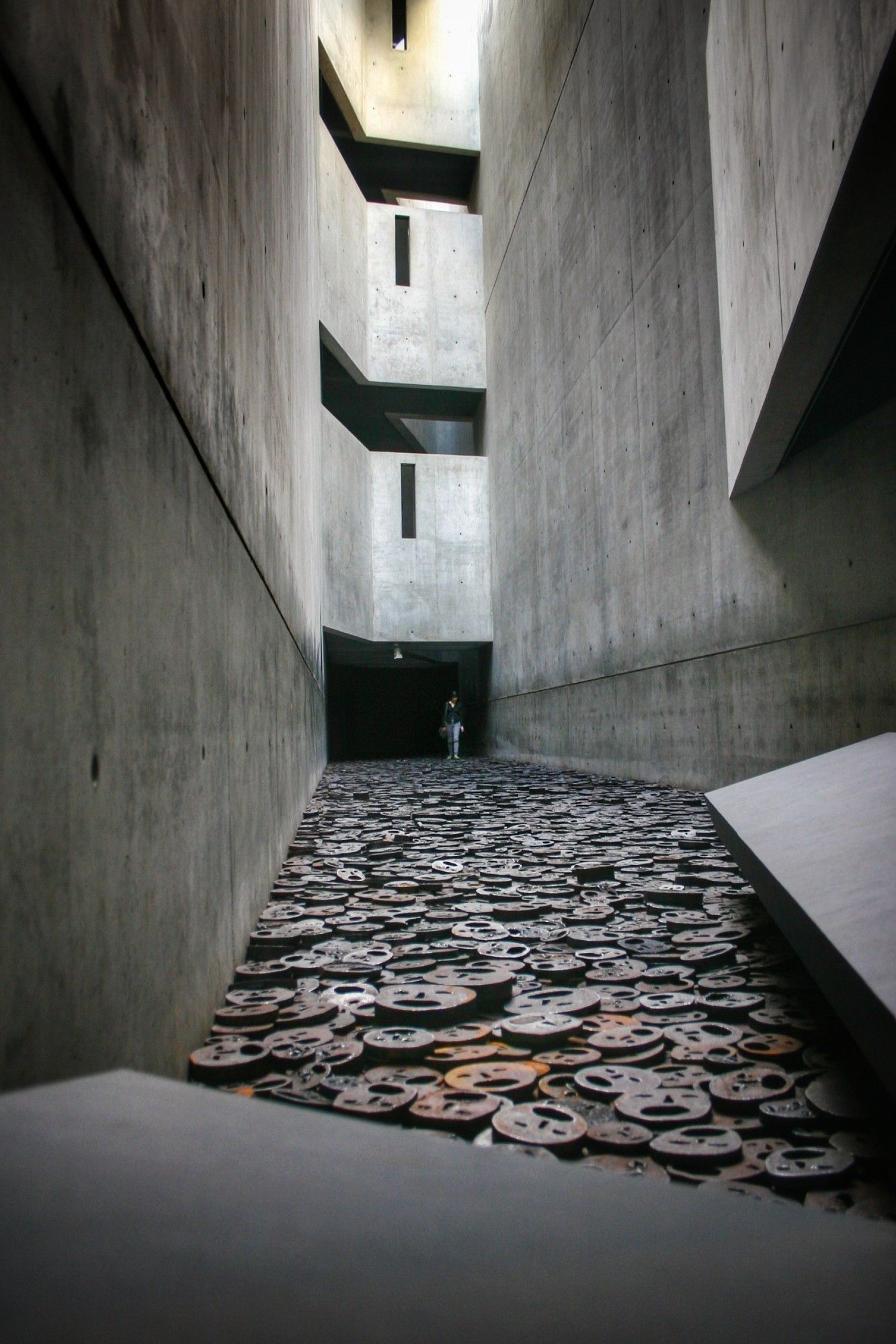 Ein Innenhof im Museum, am Boden liegen teilweise rostige stilisierte Gesichter aus Stahl, representativ für die ermordeten Juden.