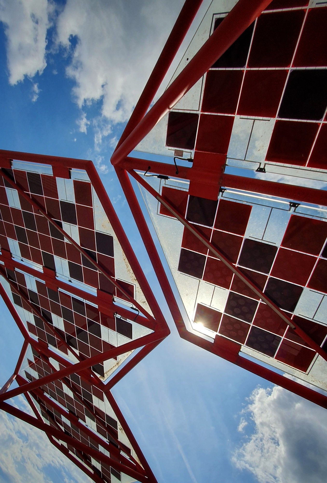 Sechseckige Schirme aus Stahl und Glas, auf denen kleine quadratische Solarzellen als Muster montiert sind.