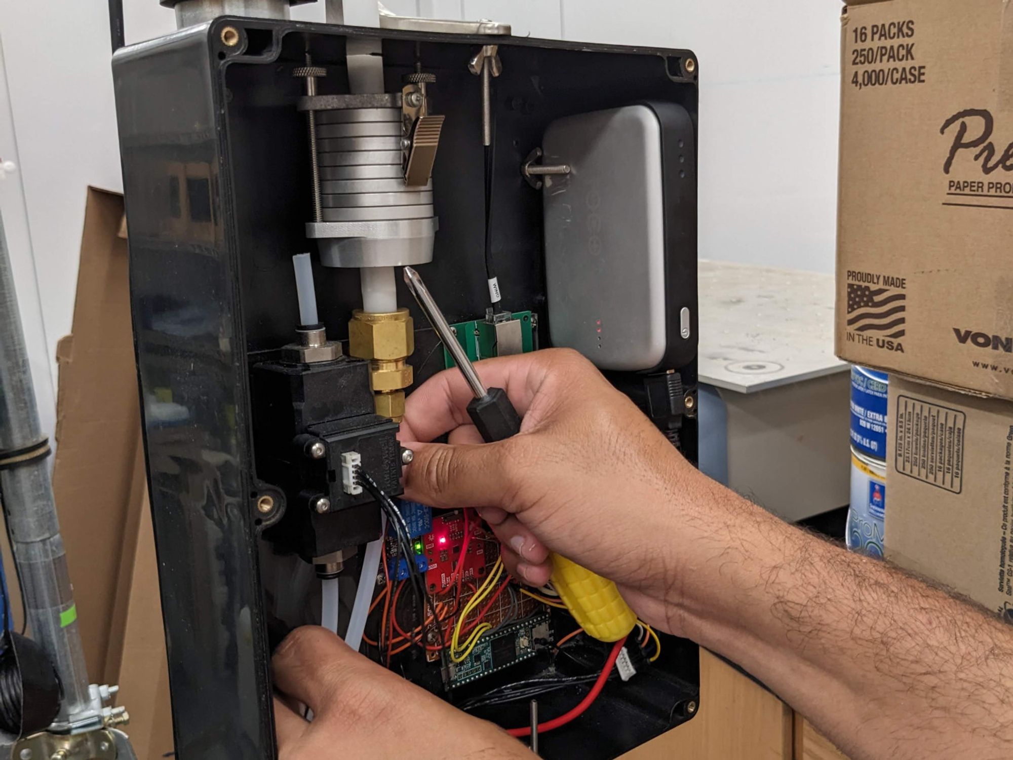 Innards of a custom air sampling device: battery, pump, electronics, cascade impactor