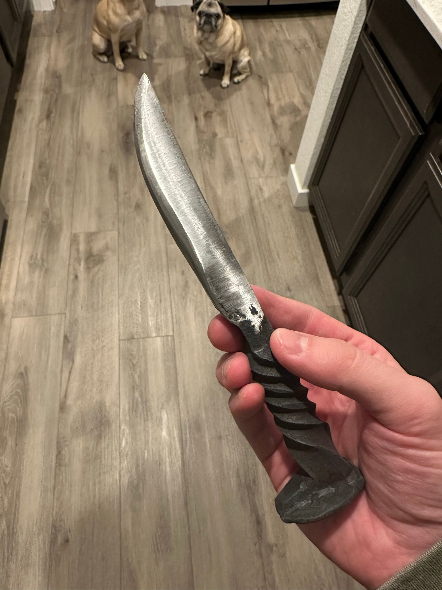 Photo of my hand holding a knife that I forged from a railroad spike