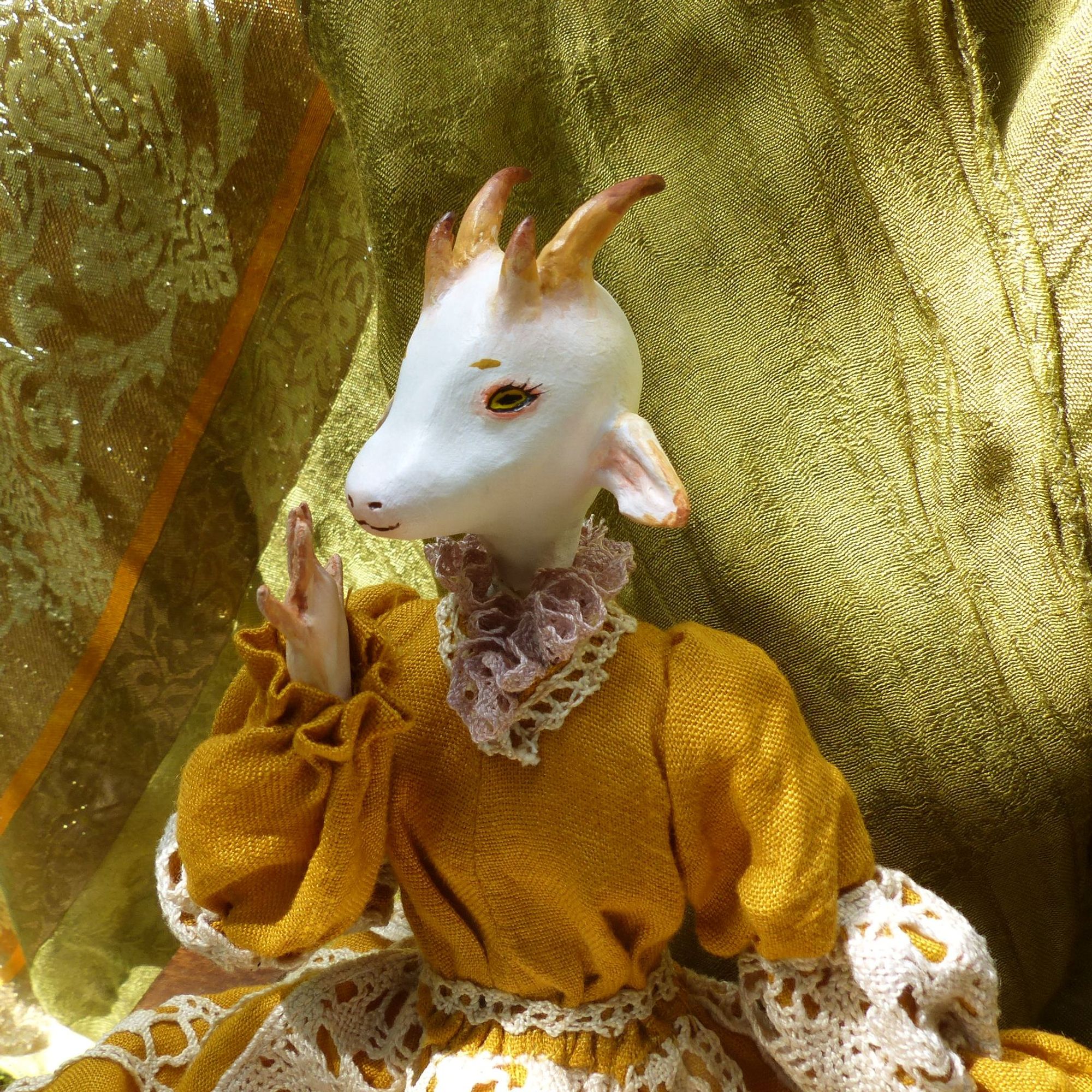 closeup portrait picture of an anthropomorphised white goat doll, wearing a mustard yellow dress with cream lace accents (very cottage core)